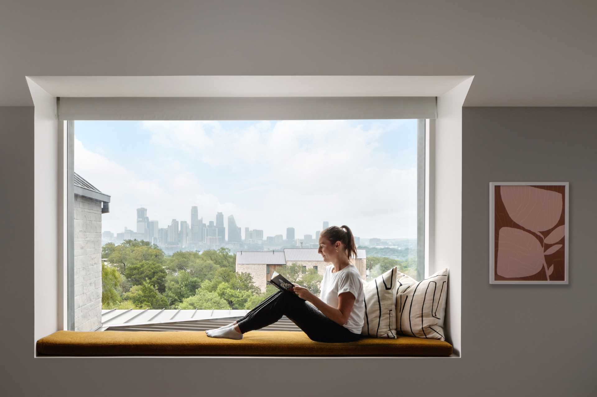 In another bedroom, a graphic wallpaper draws attention, while a window seat provides a view of the city skyline.