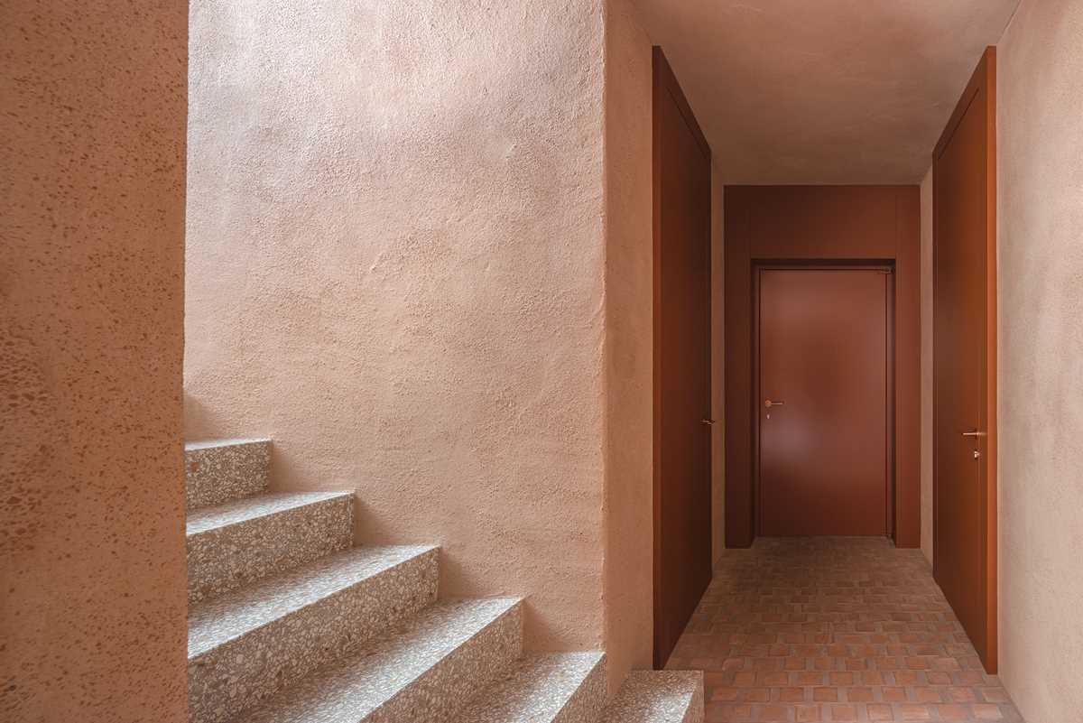 The lower level of this home features terrazzo stair treads, while the clay of the square cotto tiles has been used as aggregates mixed in the thick, lime-based plasterwork of the walls.