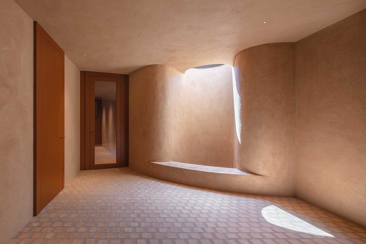 The lower level of this home features terrazzo stair treads, while the clay of the square cotto tiles has been used as aggregates mixed in the thick, lime-based plasterwork of the walls.