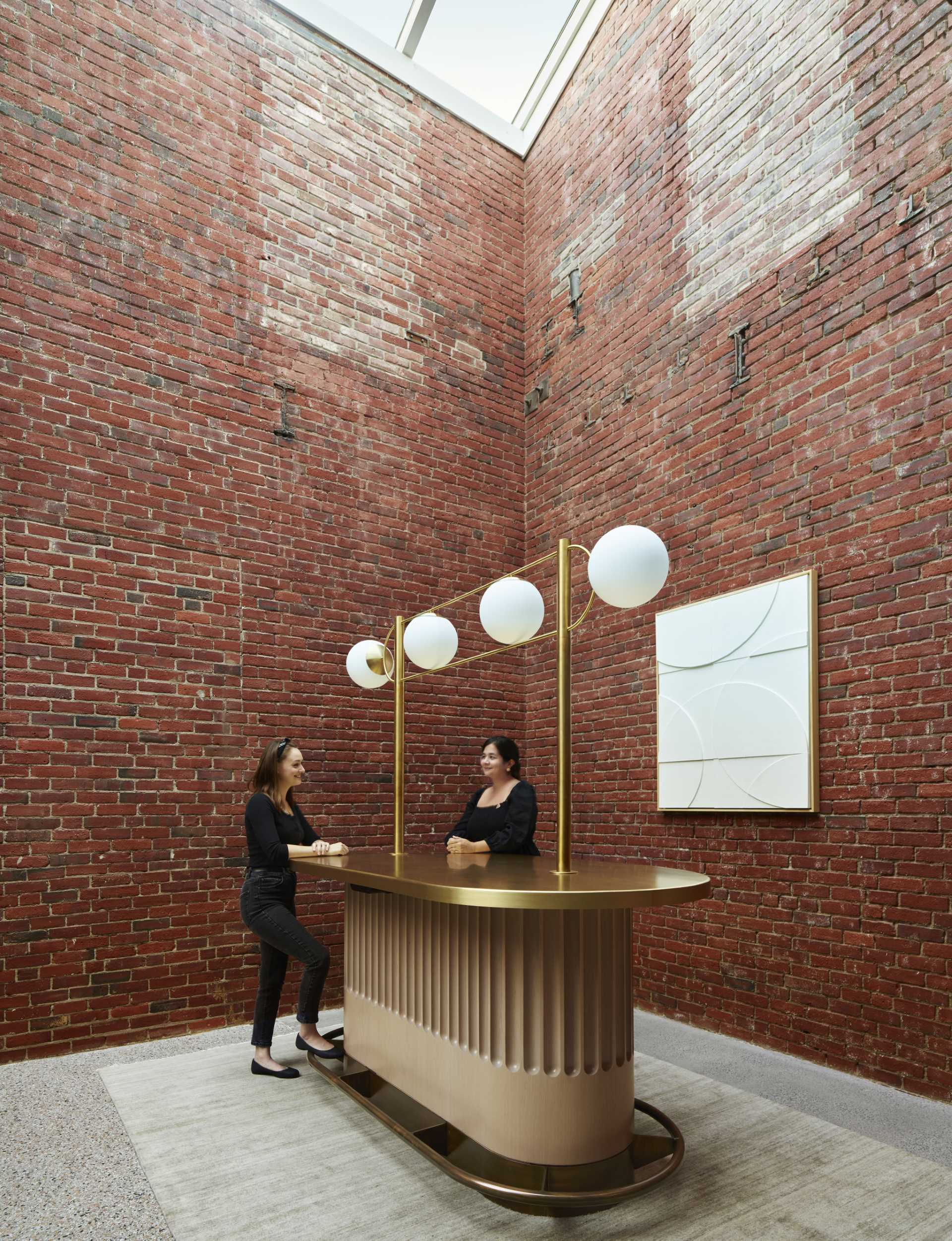 A contemporary lobby in an office building with original brick walls.