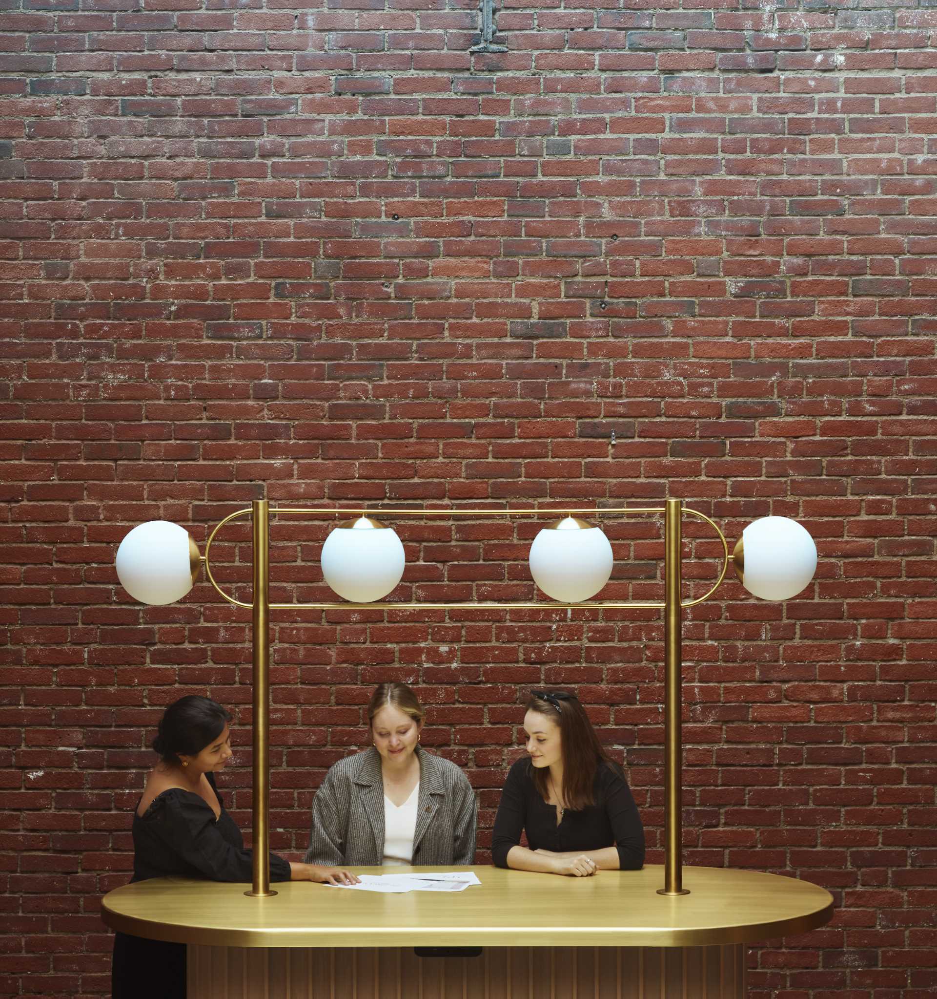 A contemporary lobby in an office building with original brick walls.