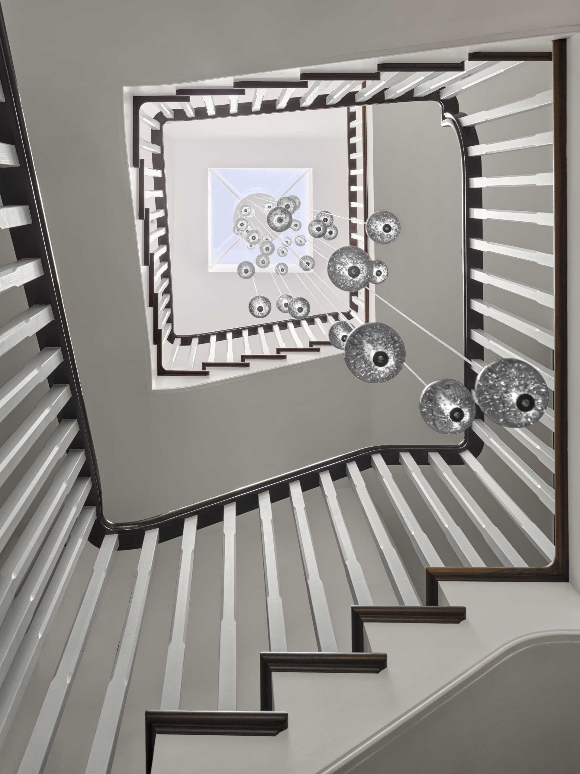 This staircase, which connects the various levels of the home, showcases a Bolla chandelier by Christopher Wray.