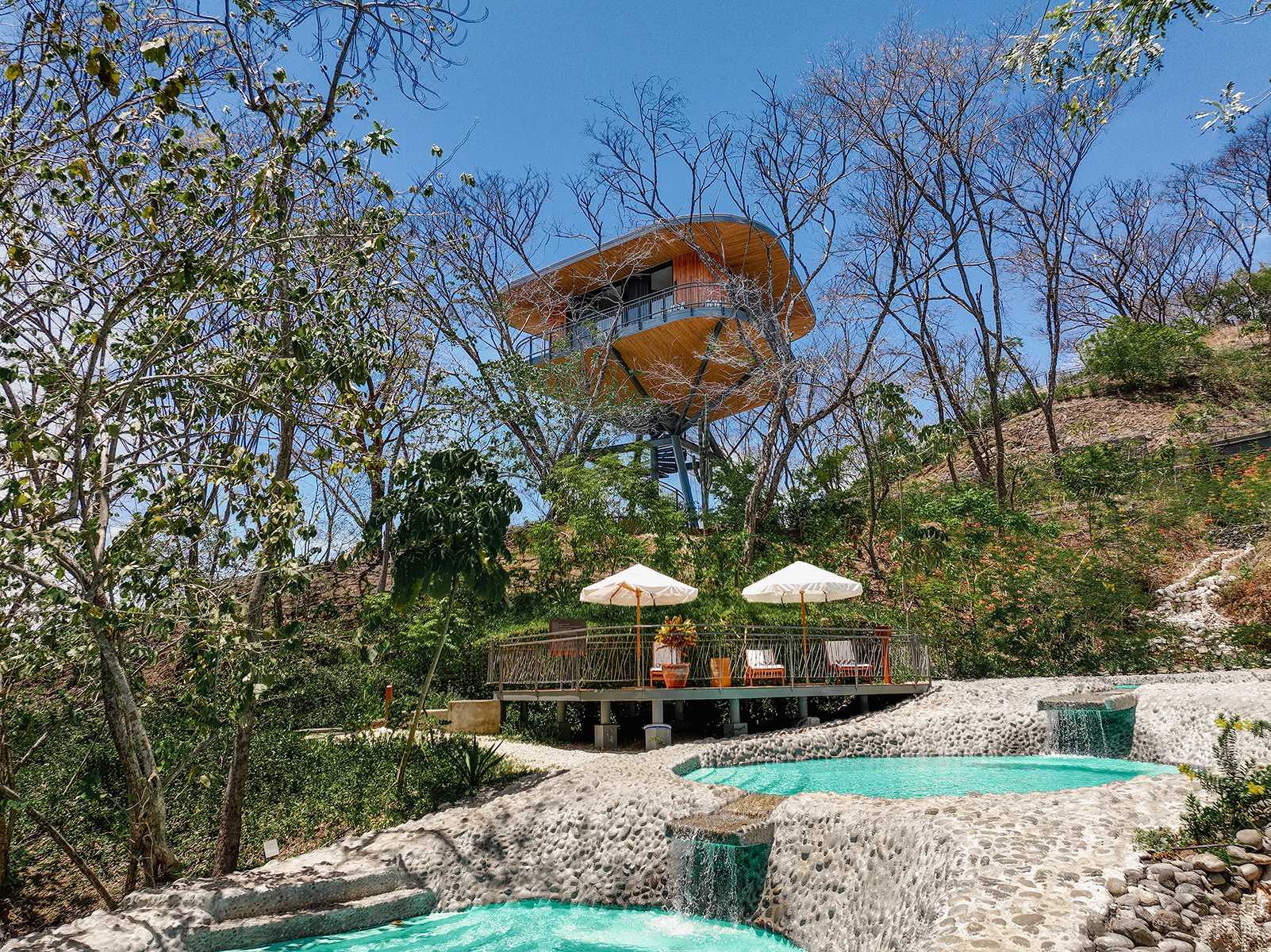 These swimming pools each have a round shape and are tiered allowing the water to flow between them.