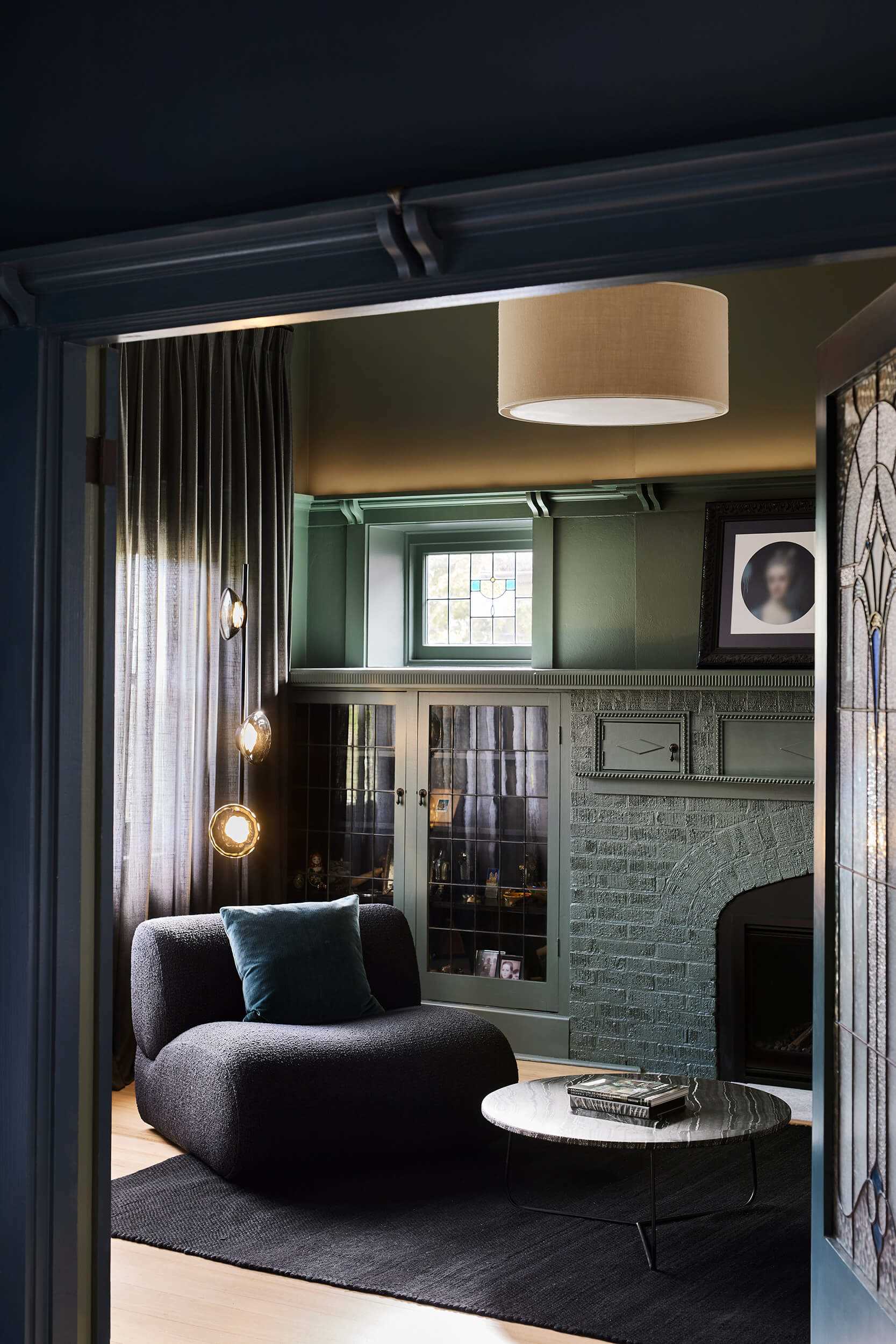 In this living room, the details of the original home shine through as shown with a fireplace and built-in glass fronted cabinets.