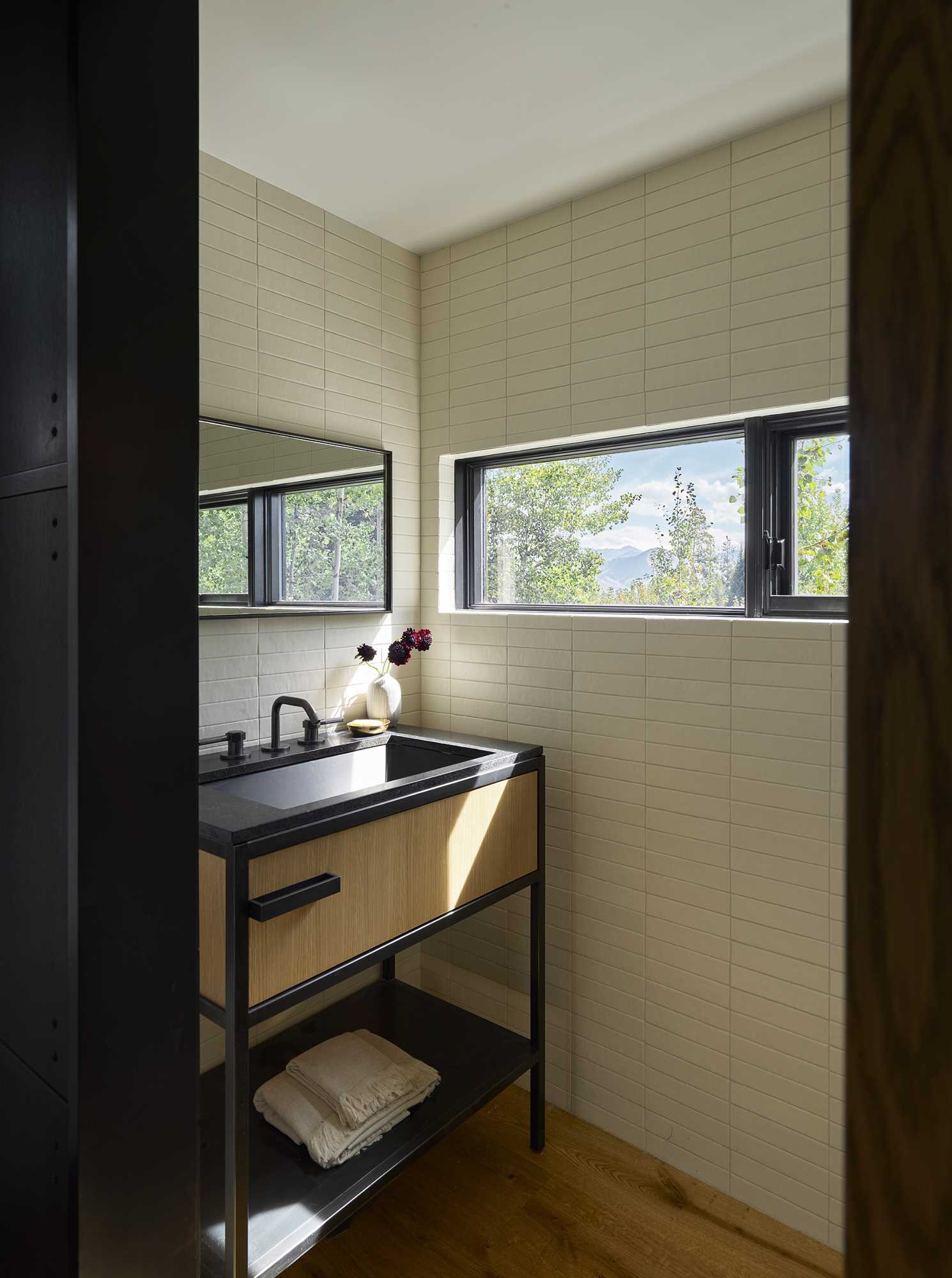 This powder room has a horizontal window that's the same height as the mirror.