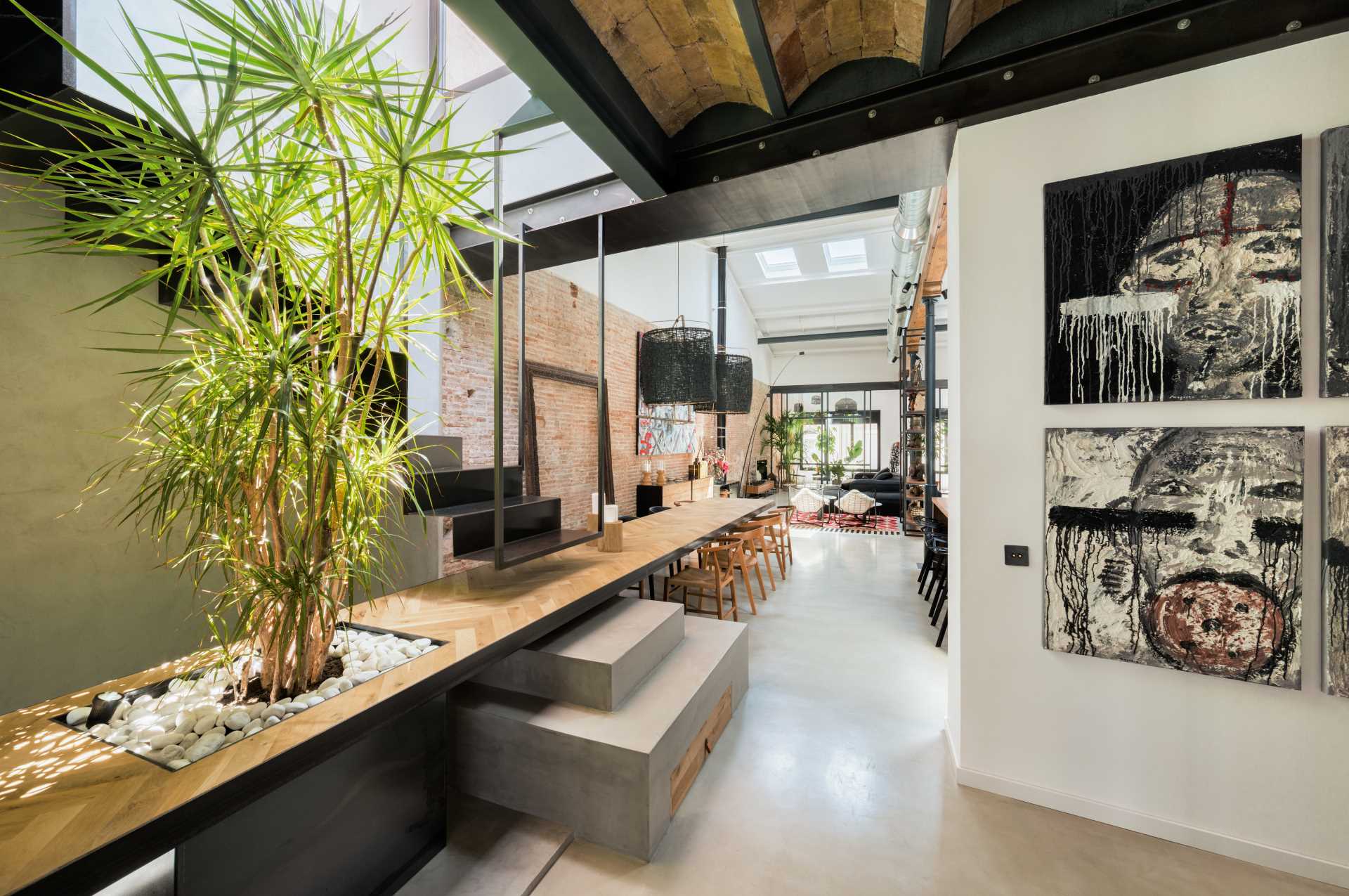 A custom-designed central structure has been designed that includes both stairs and a dining table. The dining table is an extension of the fourth step of the staircase that leads to the roof.