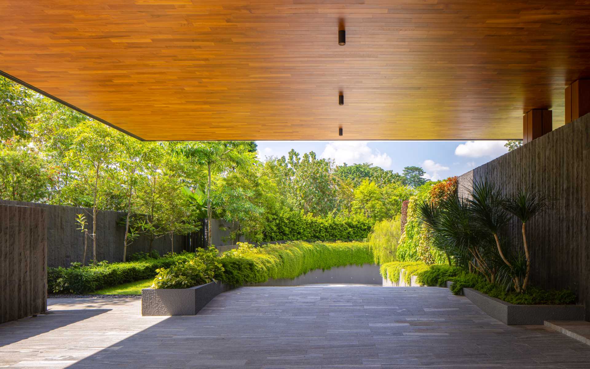 A modern home with a curved driveway that leads underground.