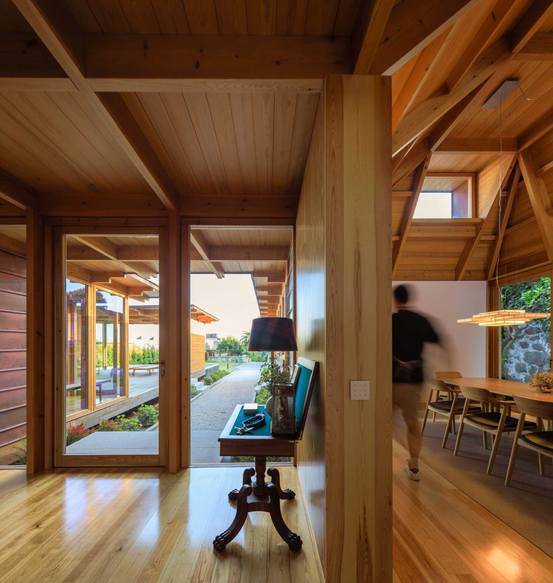 A modern dining room with an angular wood ceiling.