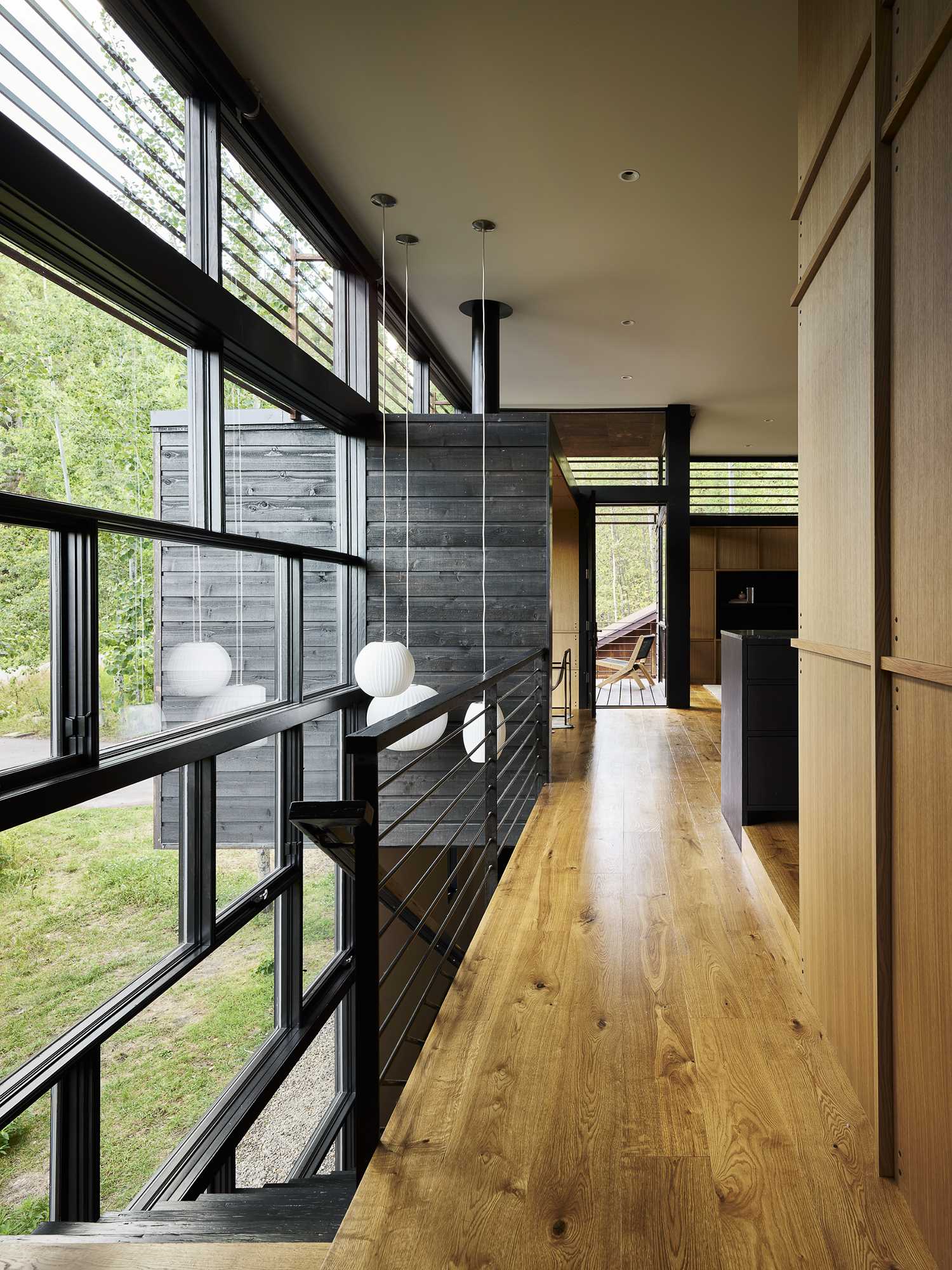 Stairs by the two-story window lead from the upper level of the home down to the guest room.