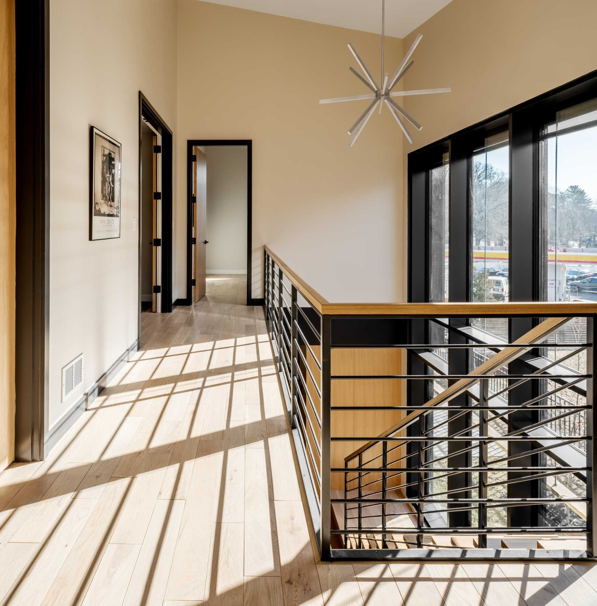 A modern home has black door frames that complement the stair railing and the window frames on the opposite wall.