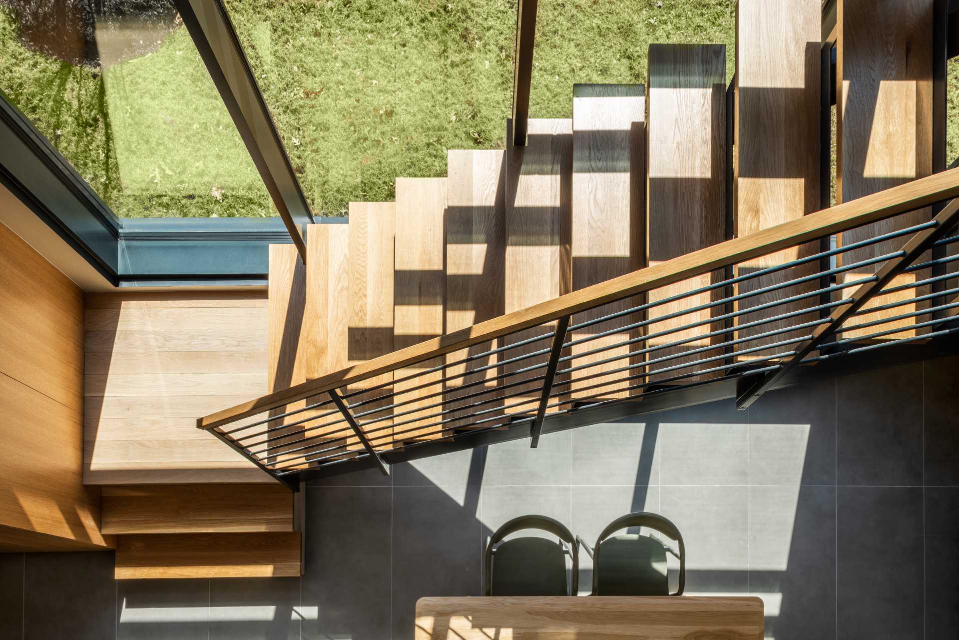 Wood and steel stairs connect the social areas with the private rooms located above.