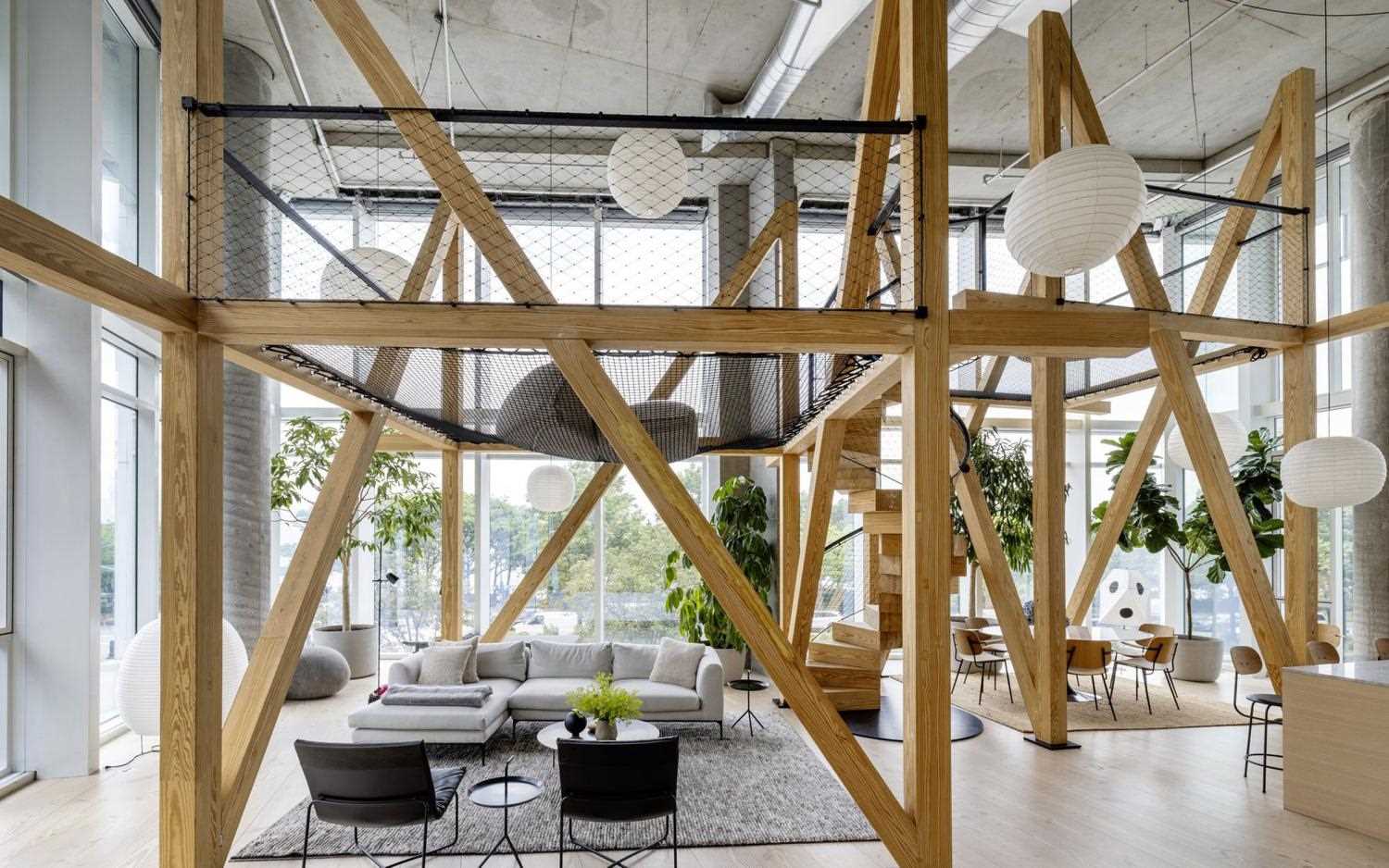 A modern apartment with 22 foot glass walls includes wood structure and netting that was inspired by a treehouse.