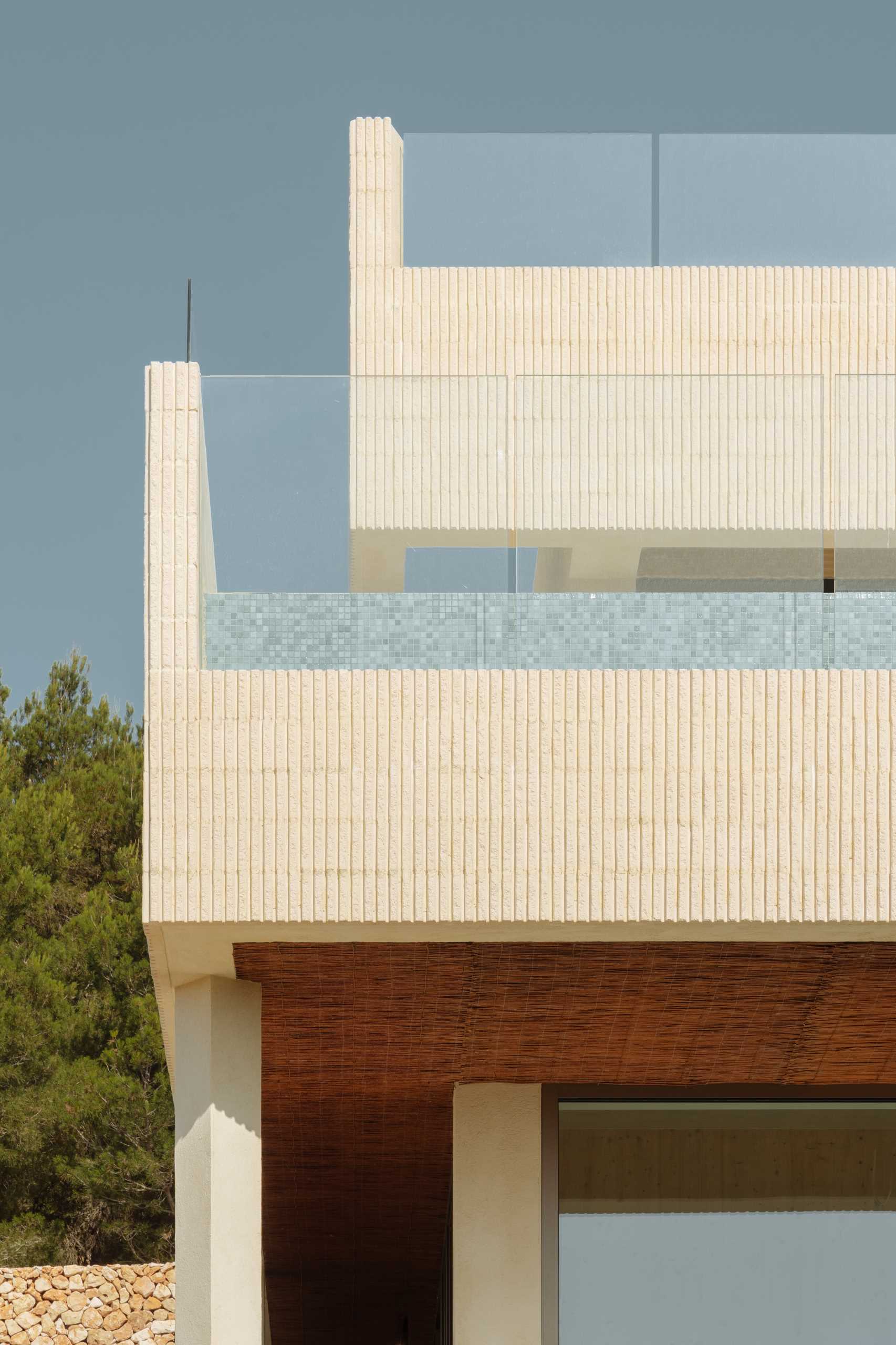 A modern multi-storey home in Menorca, Spain, that features a textured facade of fluted concrete walls.