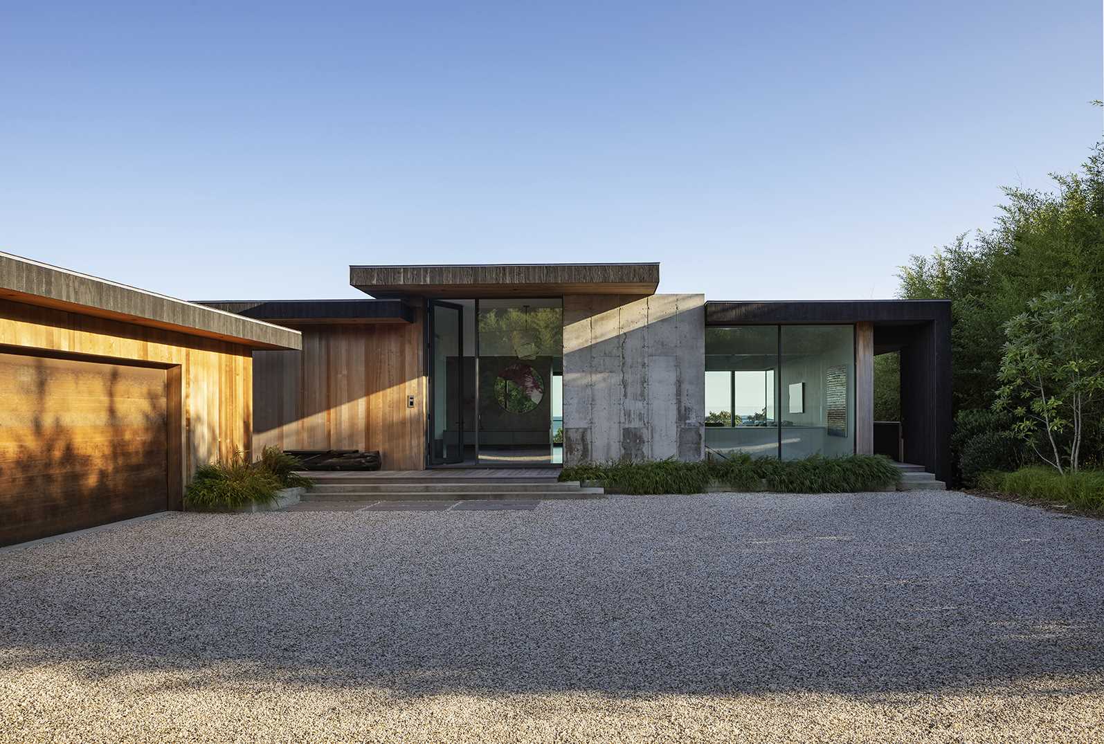 A modern home clad in charred and natural cedar and glass with concrete accents.