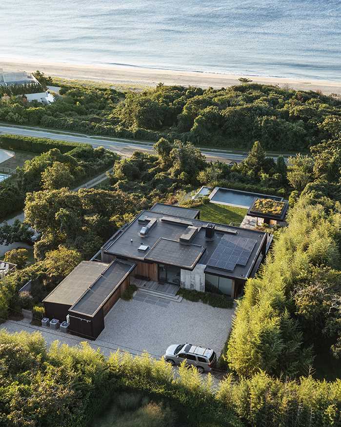 A modern multi-level home with a pool house that includes a green roof.