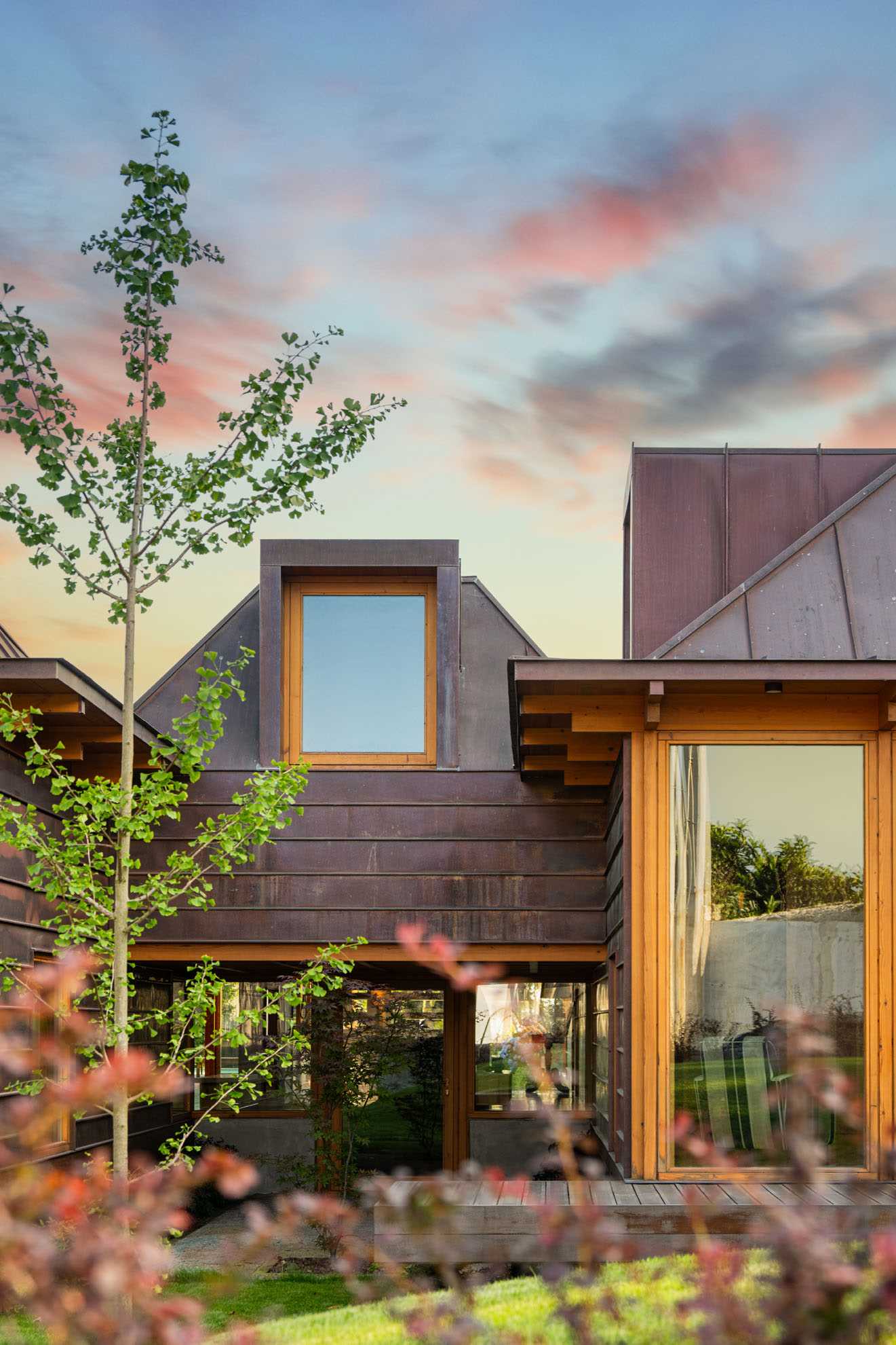 A modern house with copper-clad roof and copper siding, and wood framing.