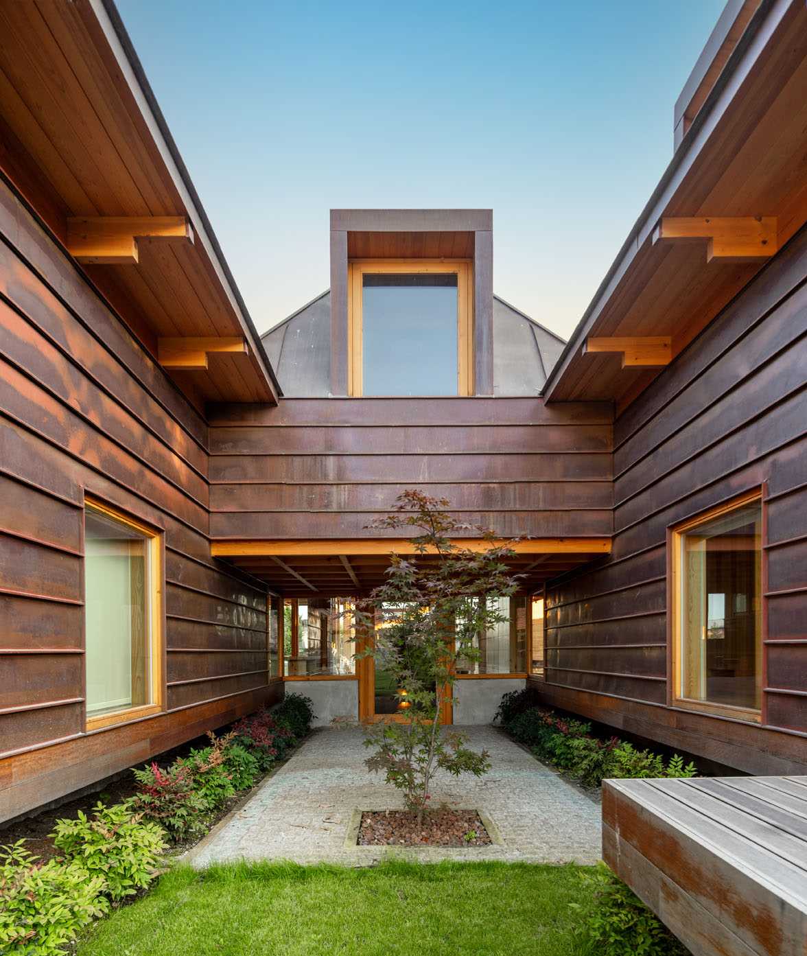 A modern house with copper-clad roof and copper siding, and wood framing.