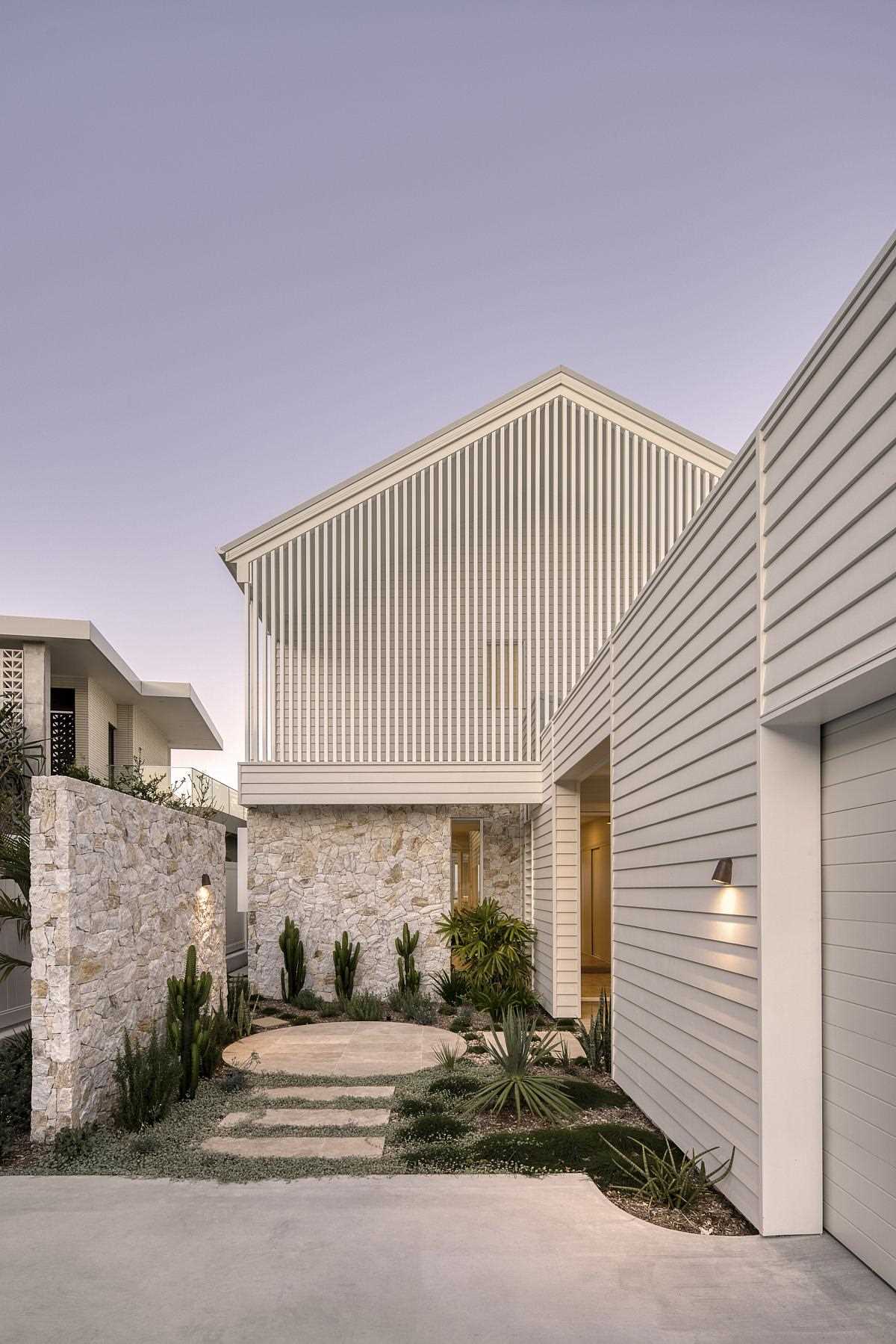 Inspired by coastal living, this modern home features an exterior of white weatherboards and white battens.