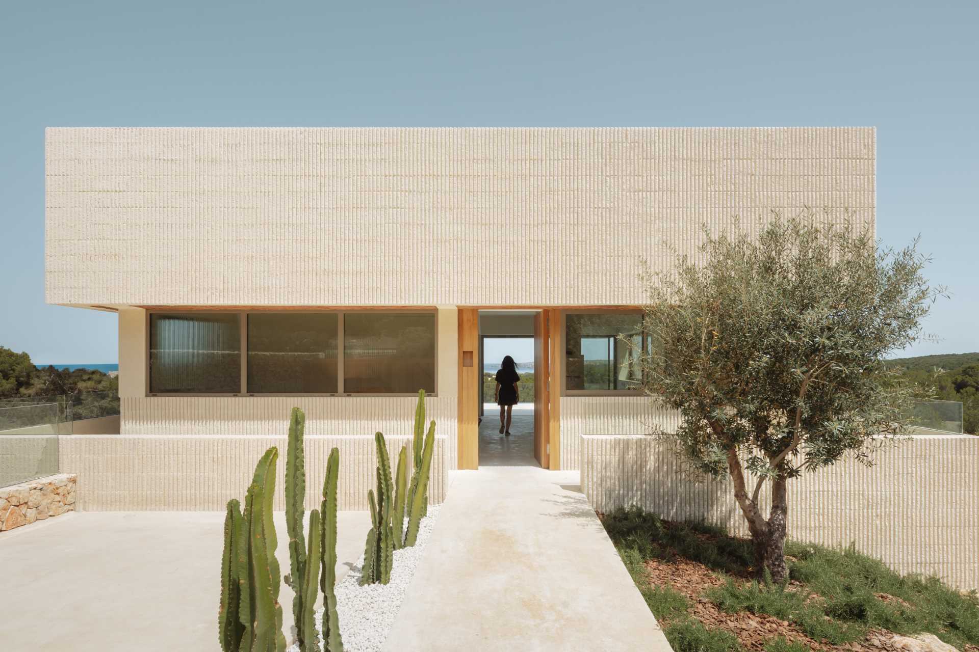 A modern multi-storey home in Menorca, Spain, that features a textured facade of fluted concrete walls.