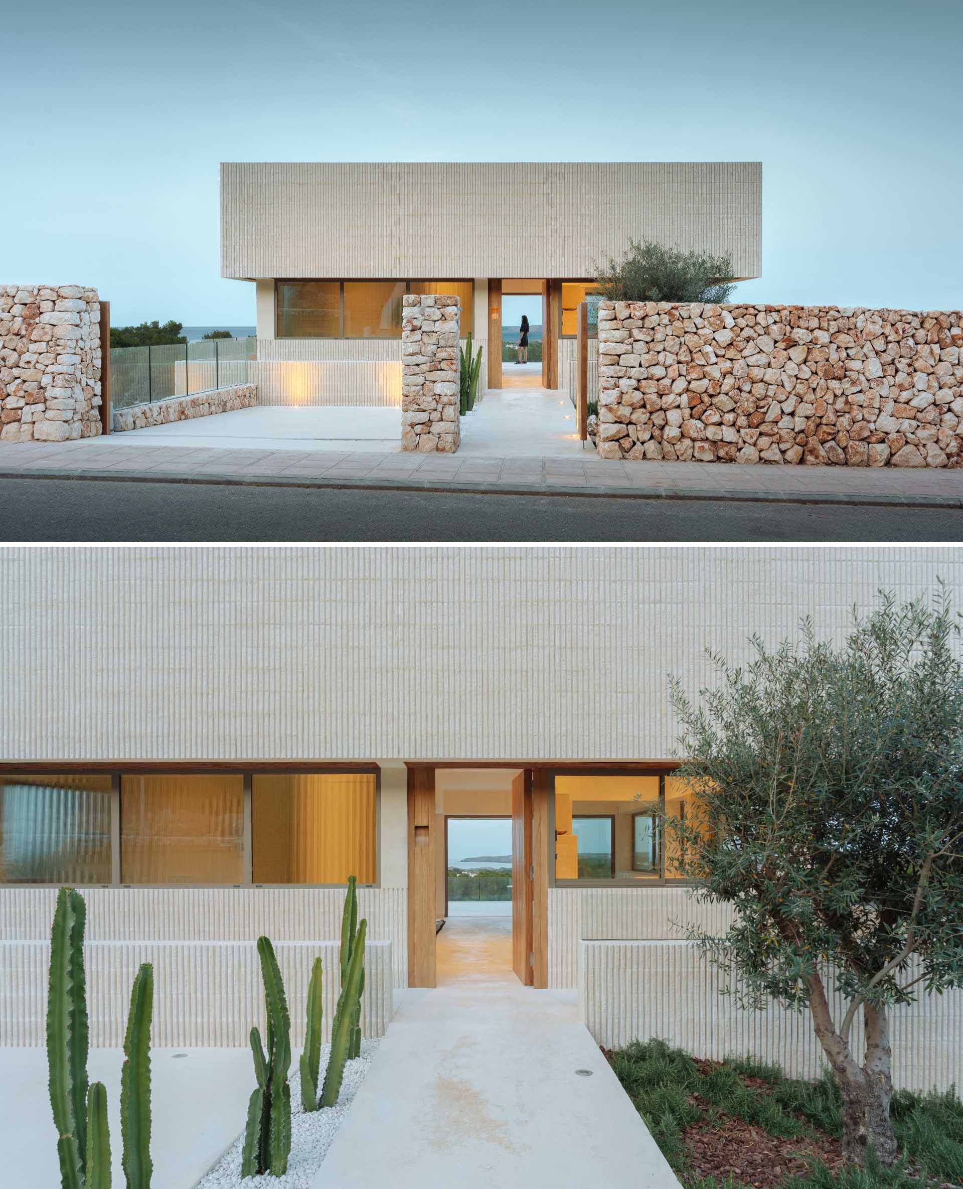 A modern multi-storey home in Menorca, Spain, that features a textured facade of fluted concrete walls and a stone wall.