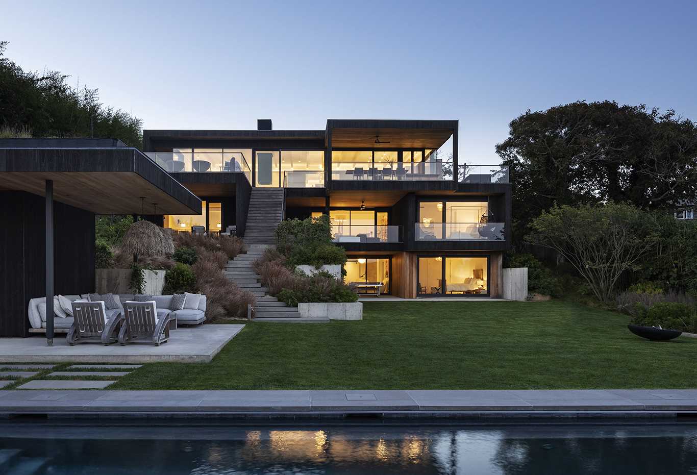 Exterior stairs of this modern home connect the various levels of the home with the garden below and the swimming pool.