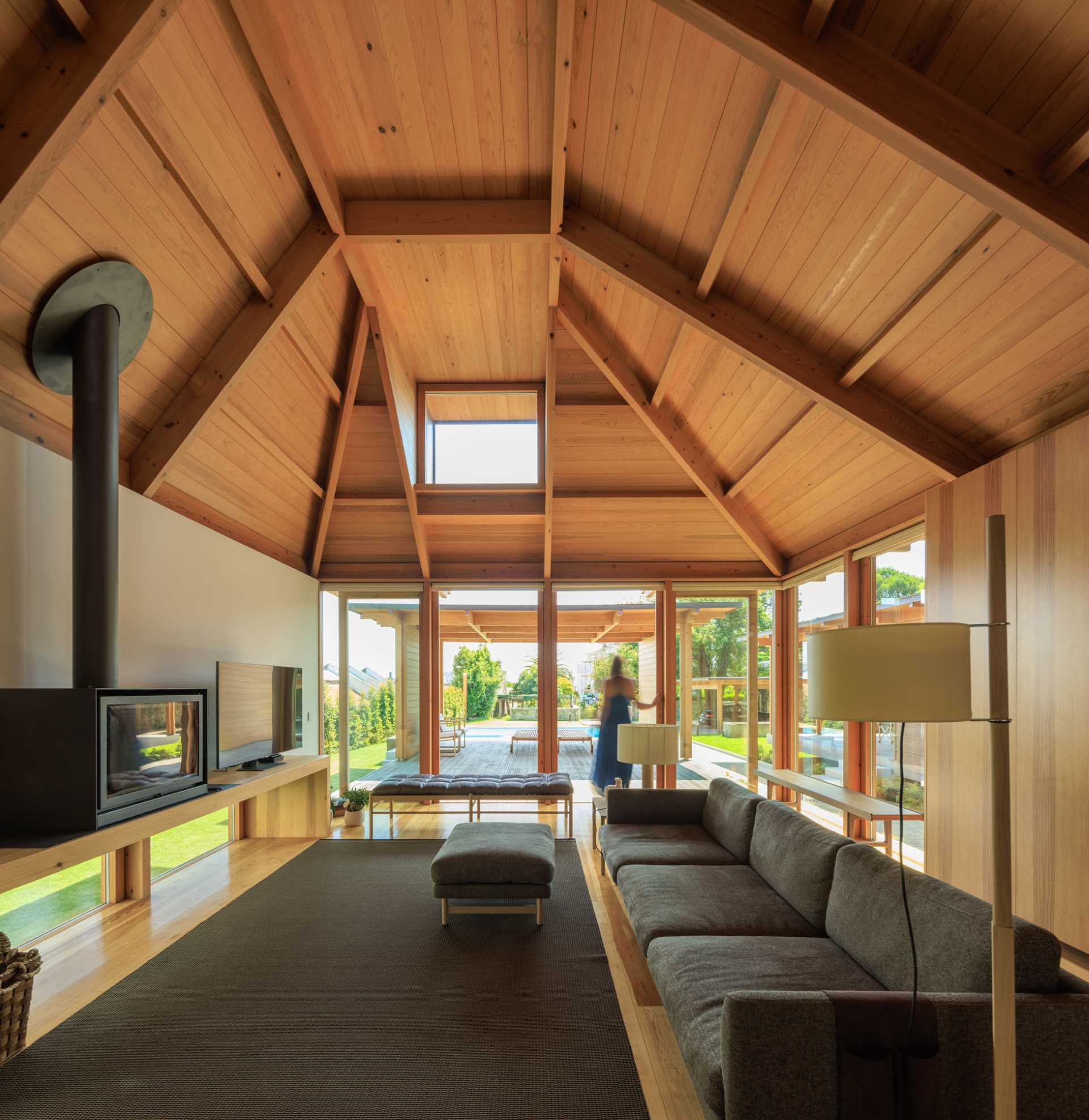 A modern living room with angled wood ceiling.