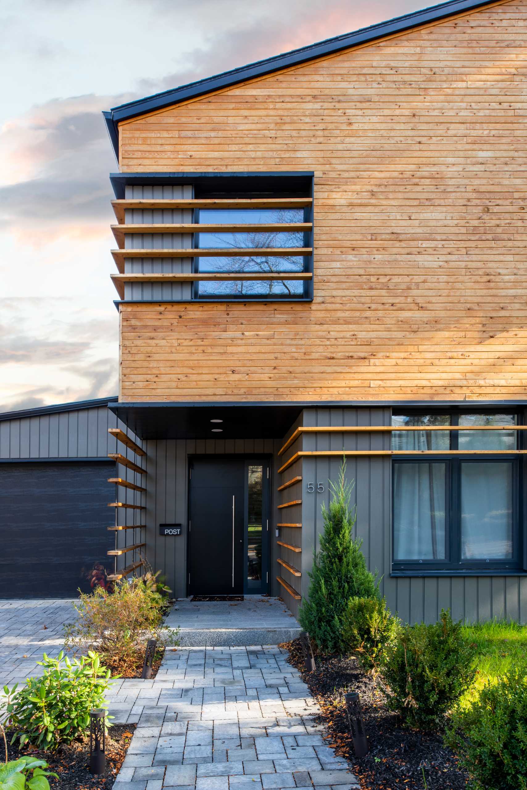 Wood louvers showcased on the wood-plank upper facade and control the light entering the central living/dining space. 