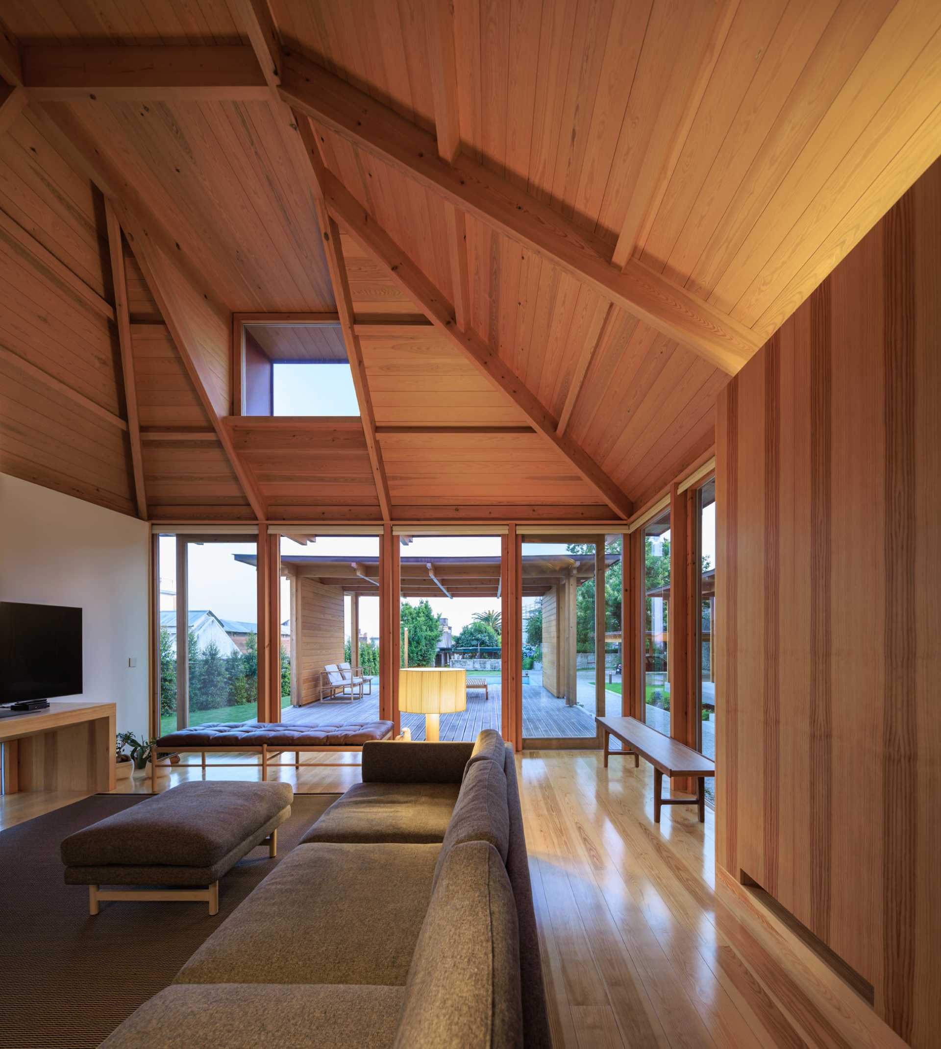 A modern living room with an angular wood ceiling.