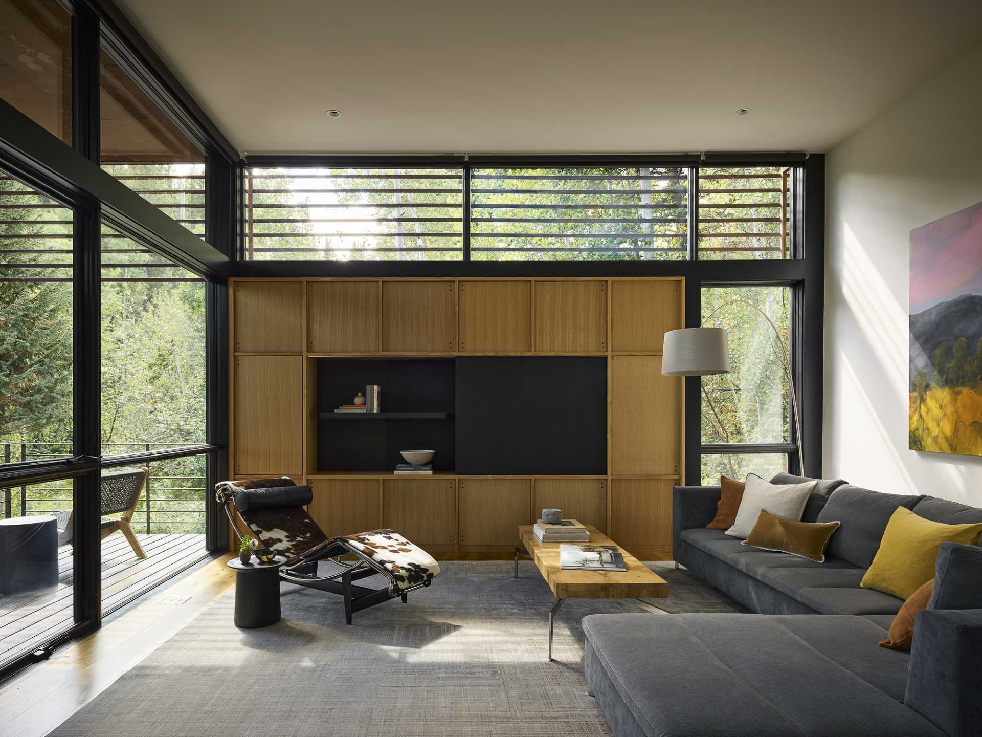A modern living room with white oak woodwork and a door that opens to a covered deck.