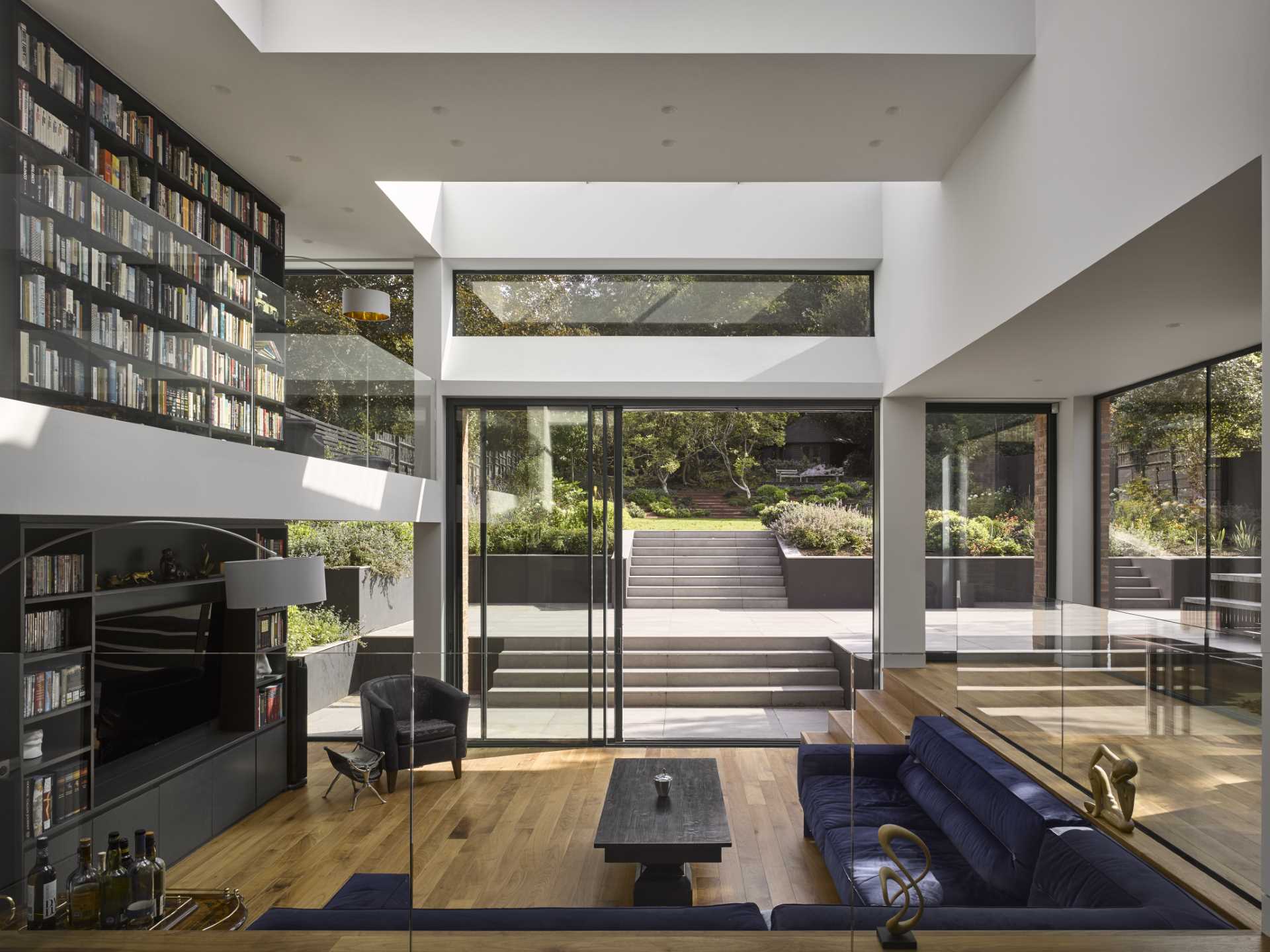 A 1920s British home received a modern rear addition with a sunken living room and mezzanine reading level.