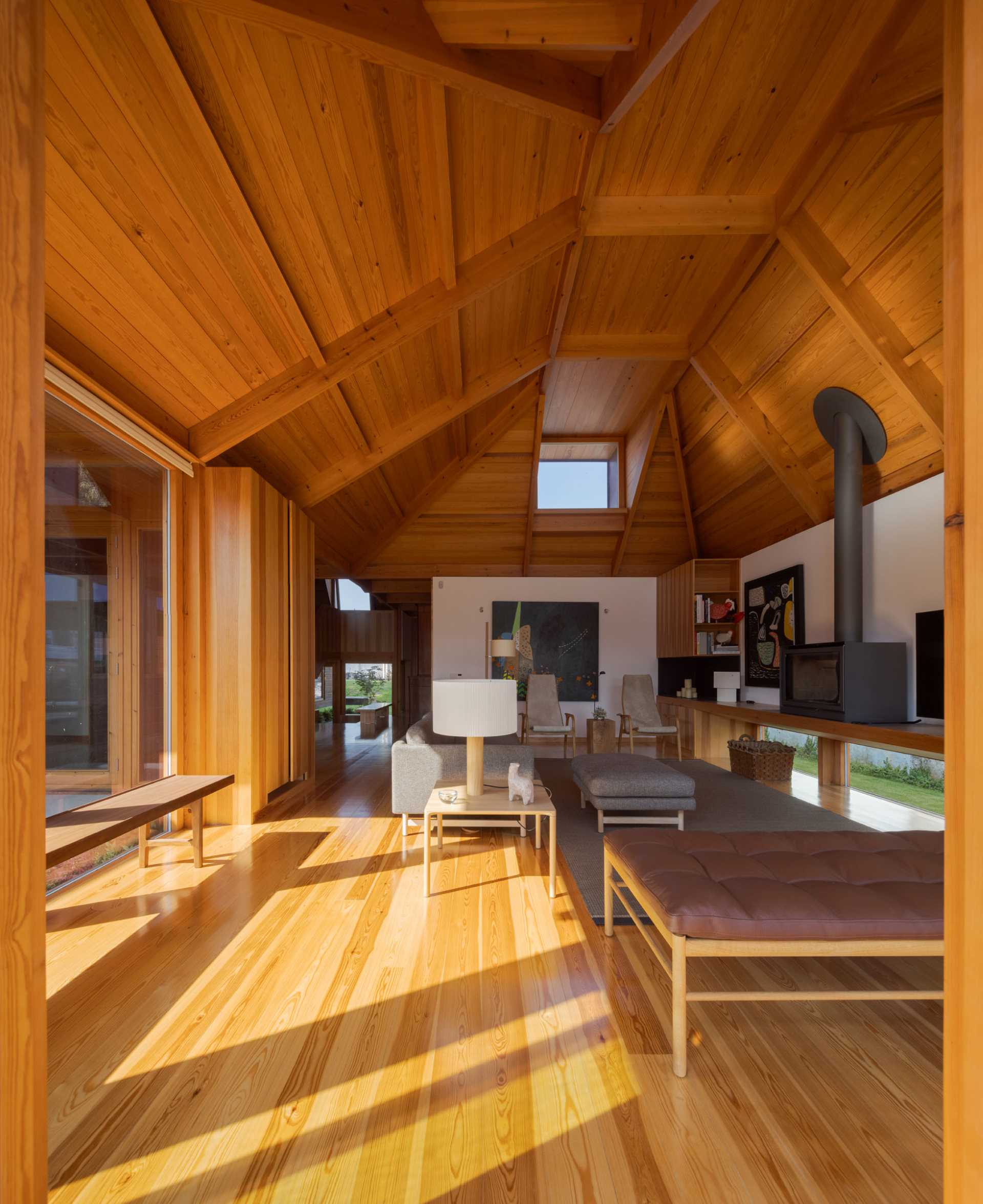 A modern living room with an angular wood ceiling.