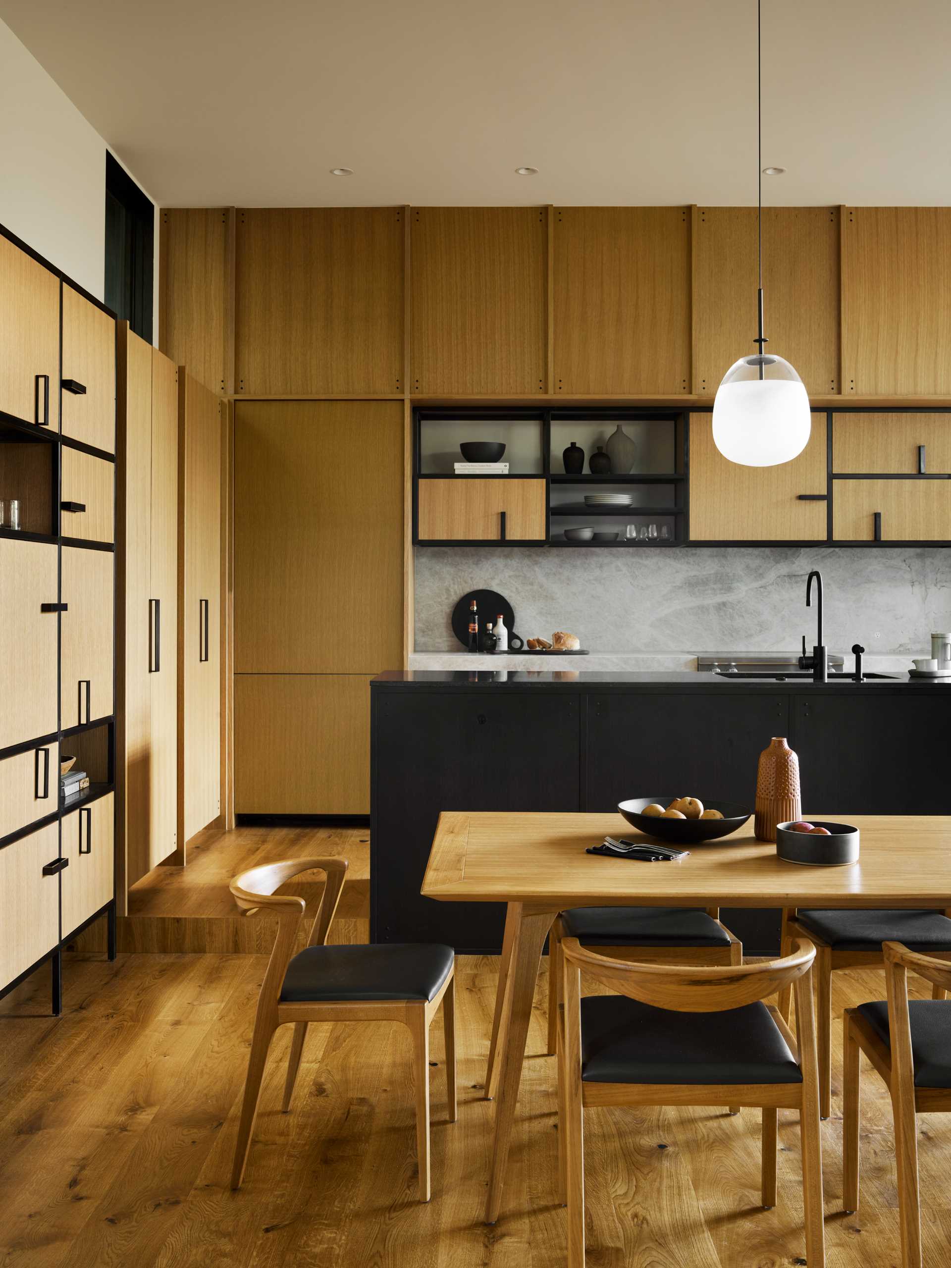 A modern kitchen with white oak cabinets and black accents.