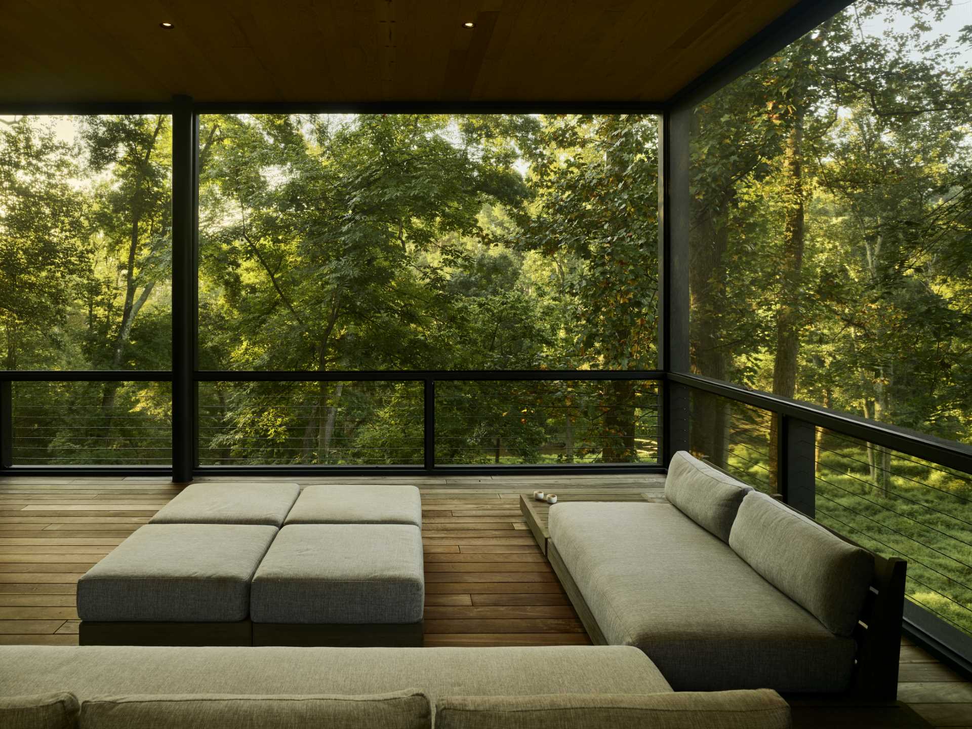 A contemporary covered outdoor space furnished with a couch.