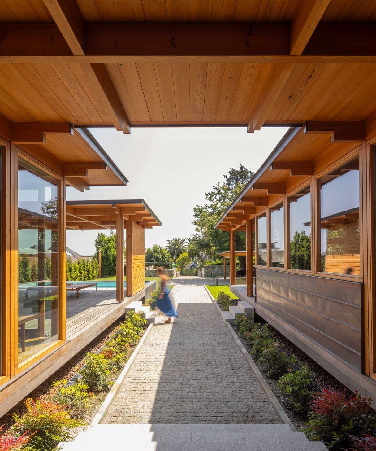 This modern house has a path that leads from the front gate, past the carport and swimming pool, and to the front door.