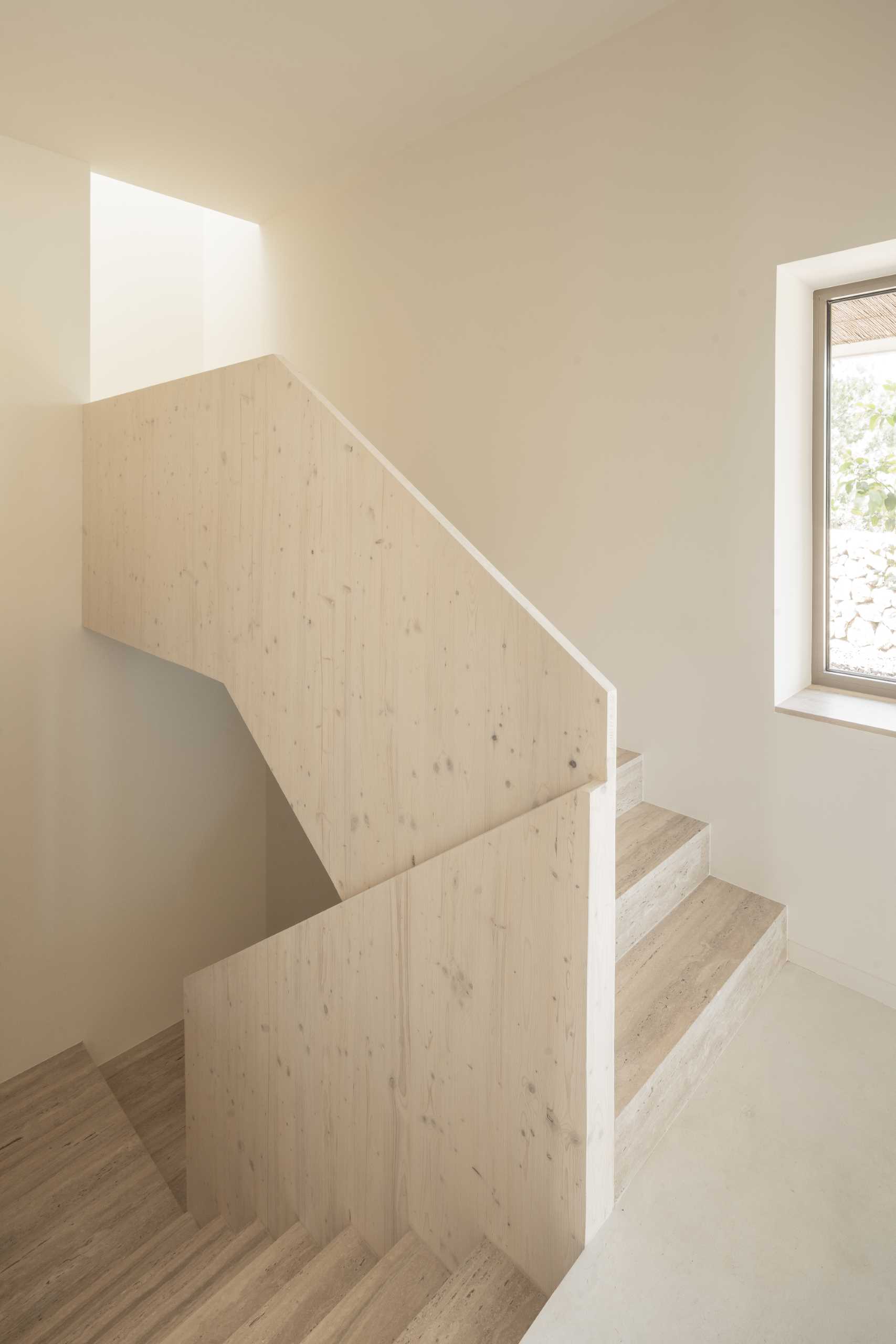 A modern ،me with travertine steps that are paired with simple white walls.