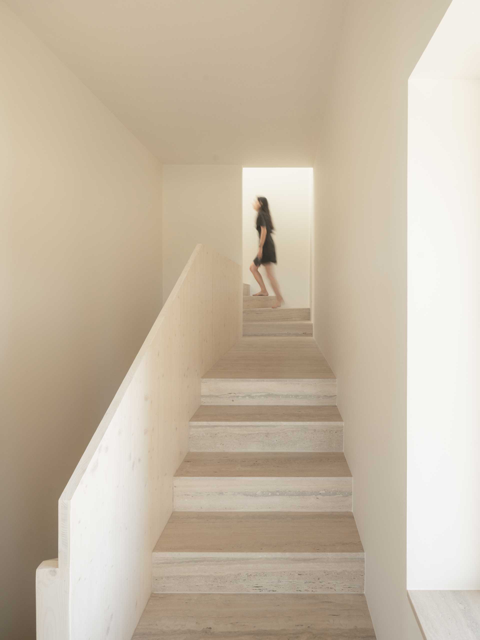 A modern home with travertine steps that are paired with simple white walls.