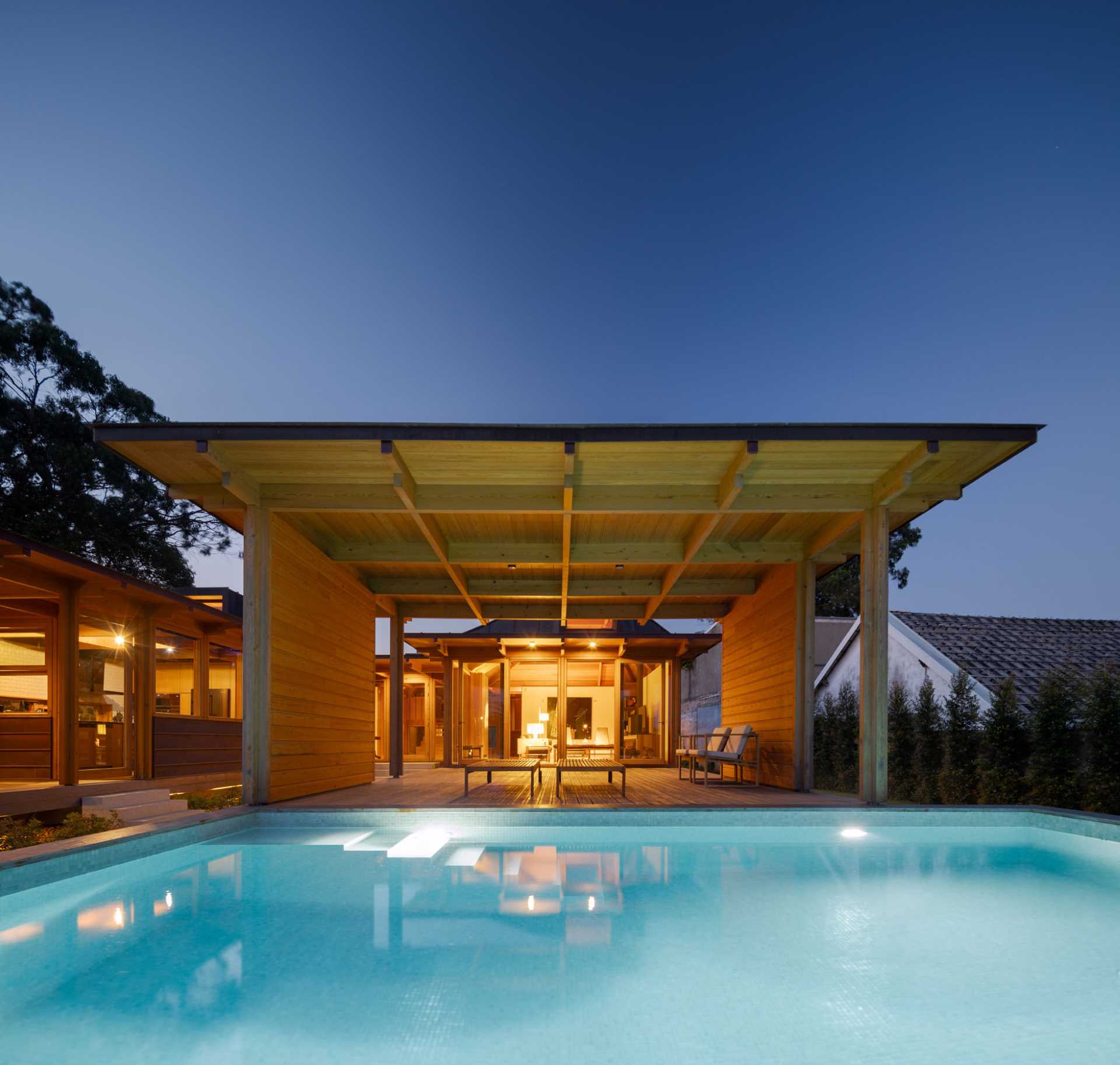 A modern house with a swimming pool and nearby cabana.