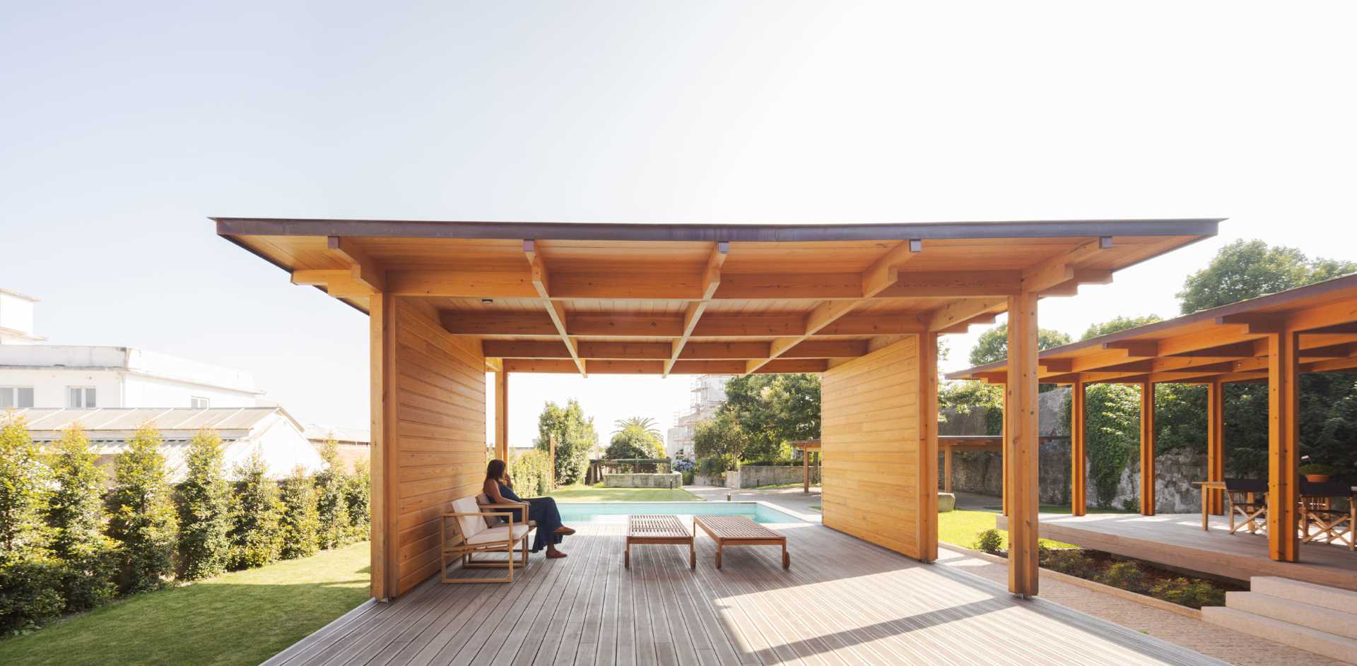 A modern house with a swimming pool and nearby cabana.