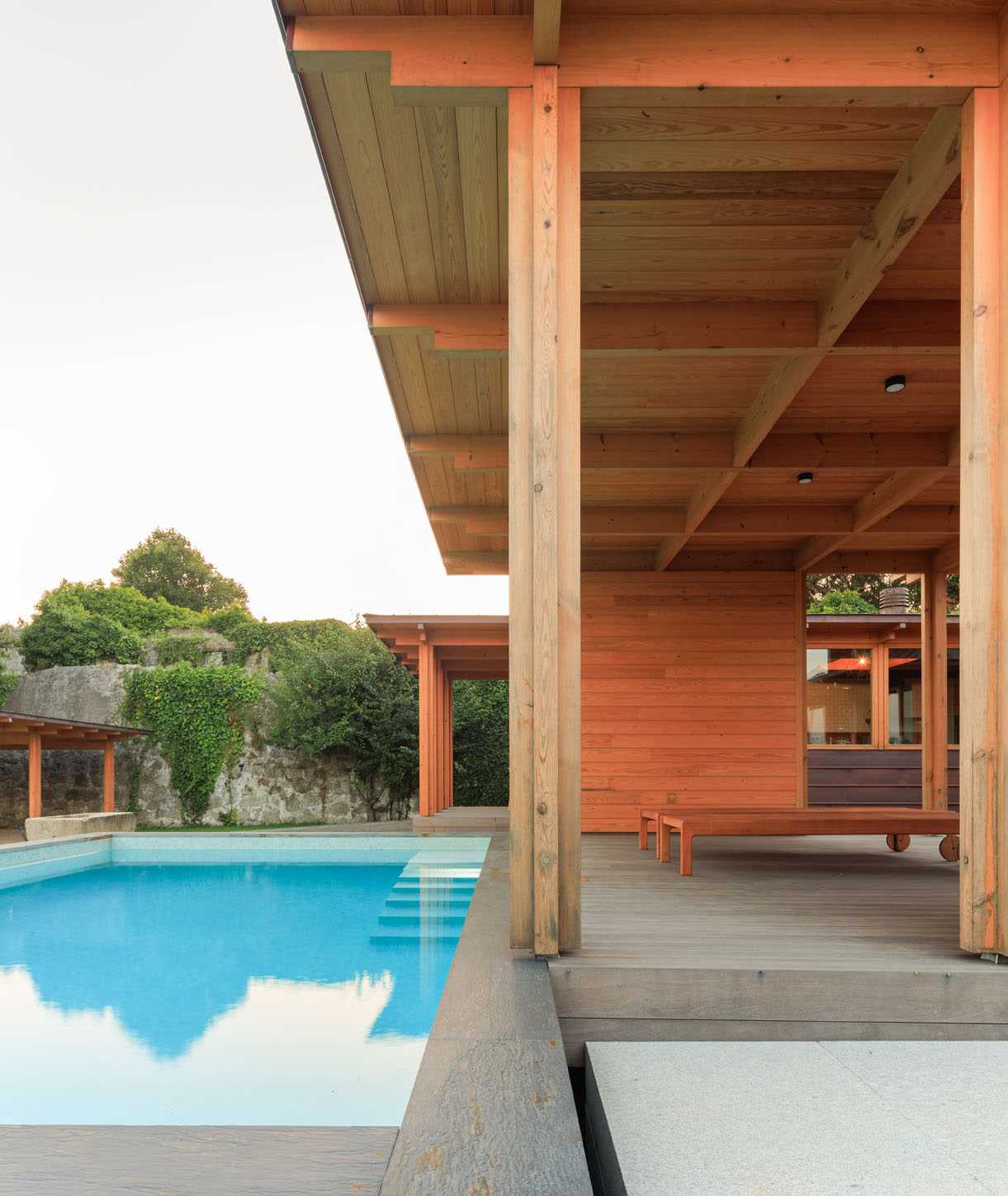 A modern house with a swimming pool and nearby cabana.