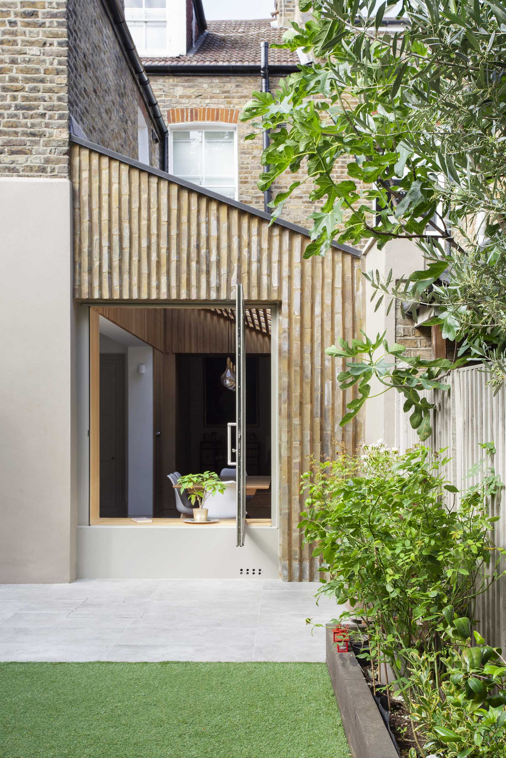 YARD Architects has shared photos of a side extension they re-imagined for a home in Greater London, England, that creates an open and bright dining area and kitchen.