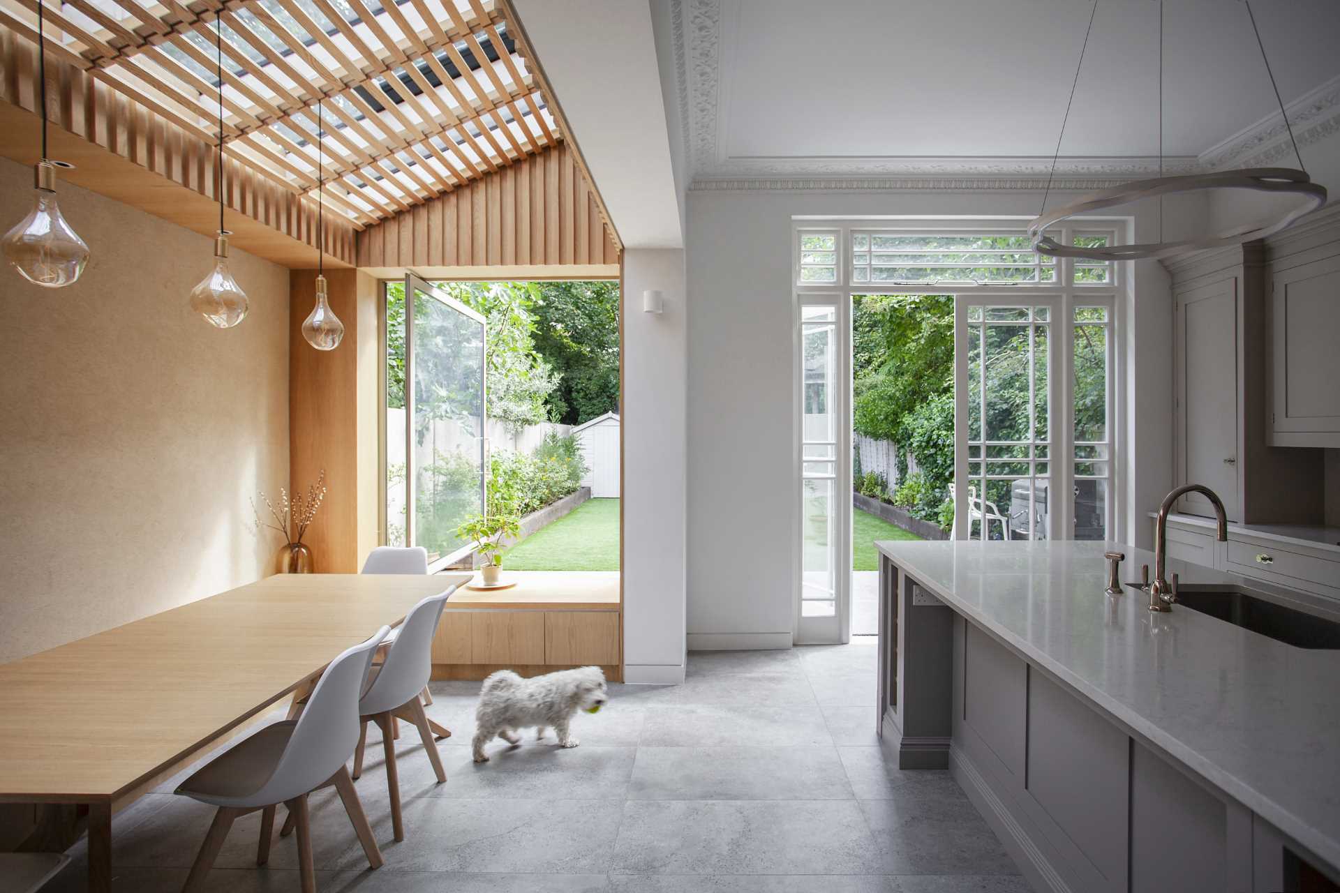 YARD Architects has shared photos of a side extension they re-imagined for a home in Greater London, England, that creates an open and bright dining area and kitchen.