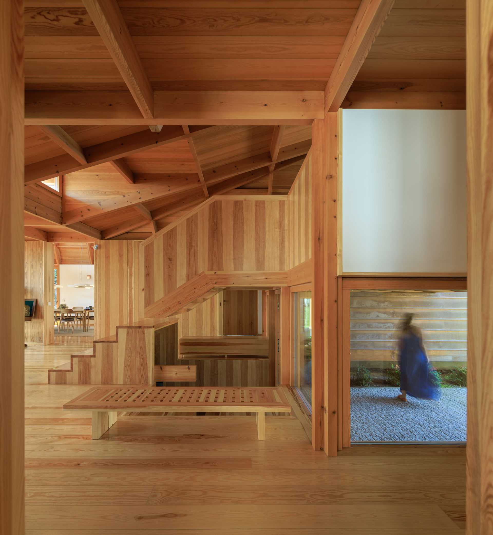 A modern house with wood walls, stairs, ceiling, and floor.