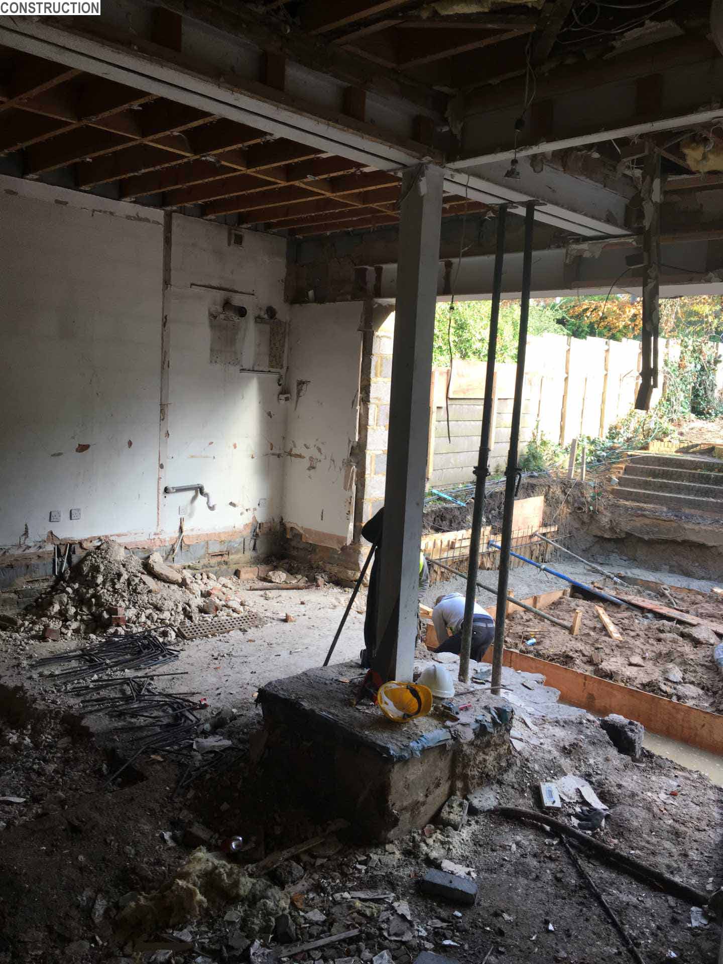 Construction photo - A 1920s British home received a modern rear addition with a sunken living room and mezzanine reading level.