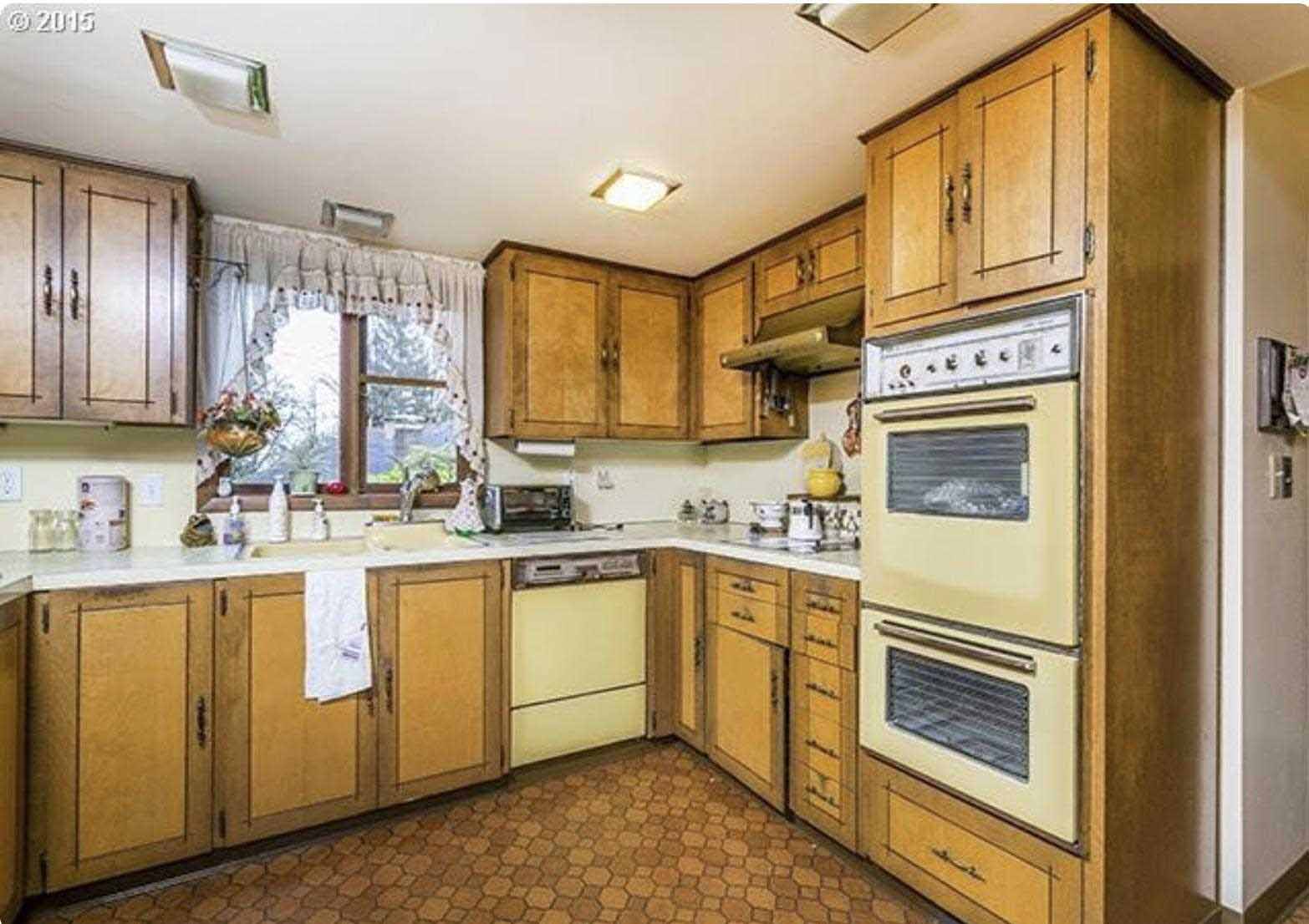 Before - The original kitchen featured wood cabinets and original appliances. 