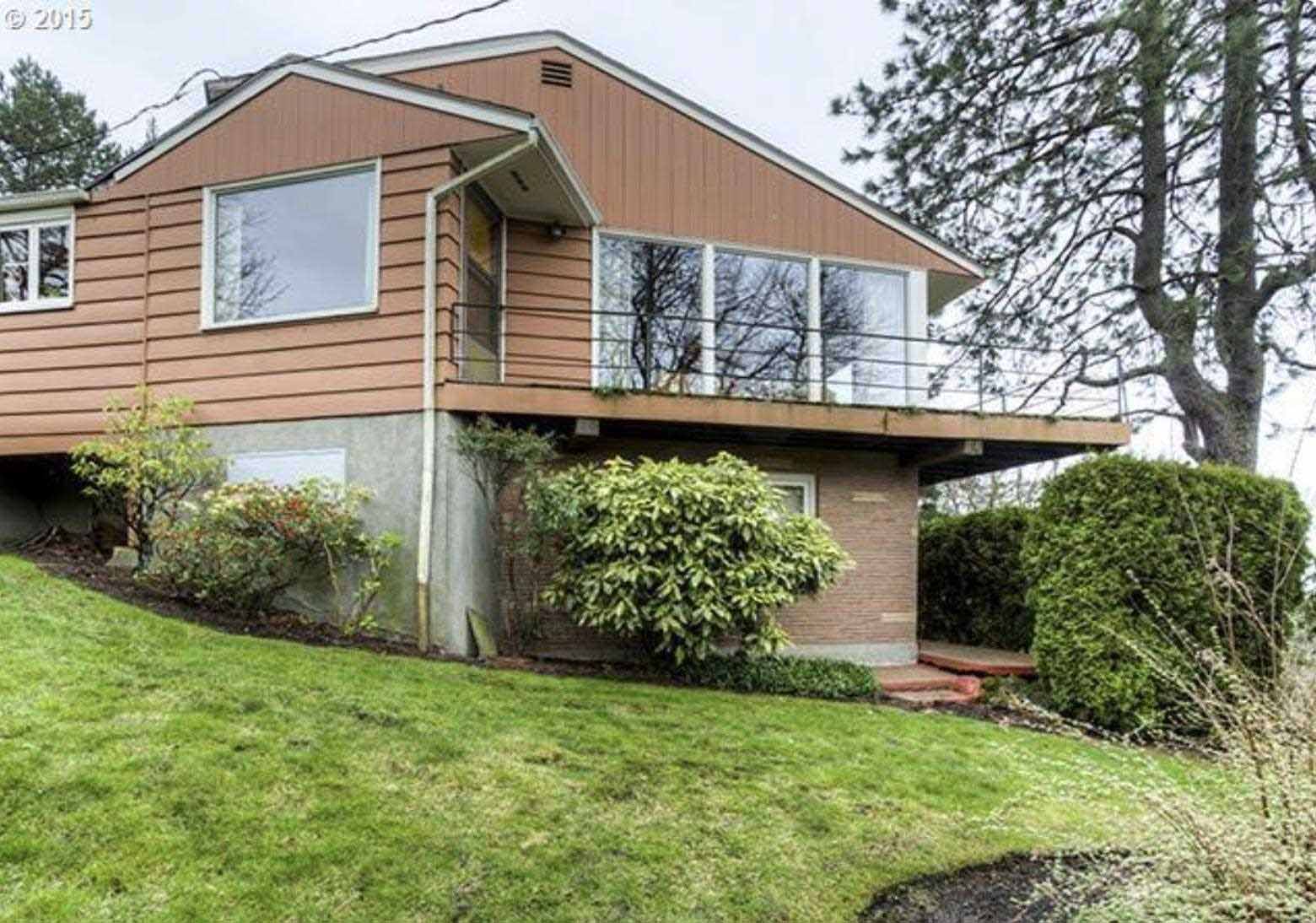 Before - The original mid-century modern home has a brown exterior with original windows and white trim.