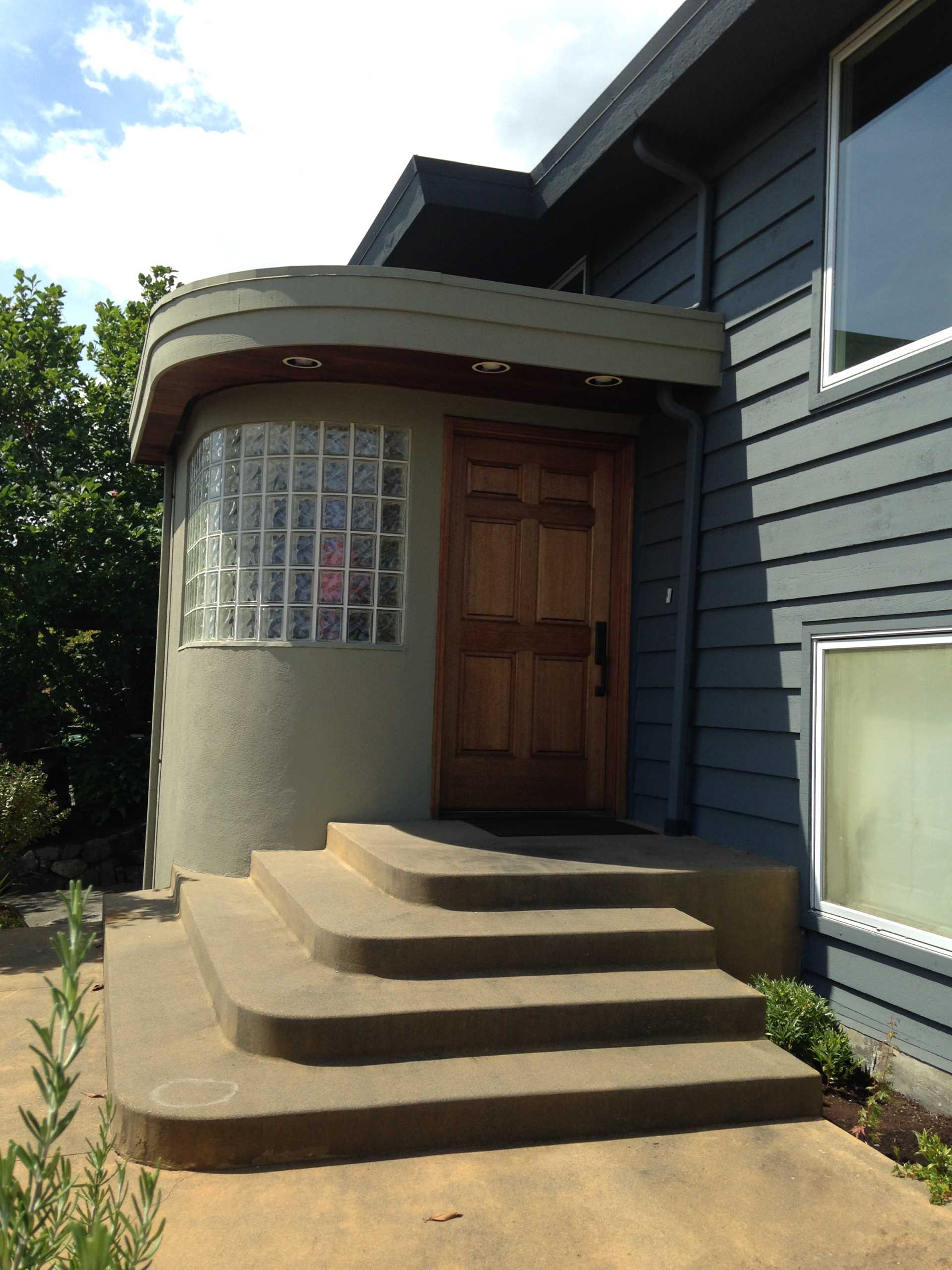 Before - The original front door was a solid wood wood nestled within a protruding addition with glass blocks.