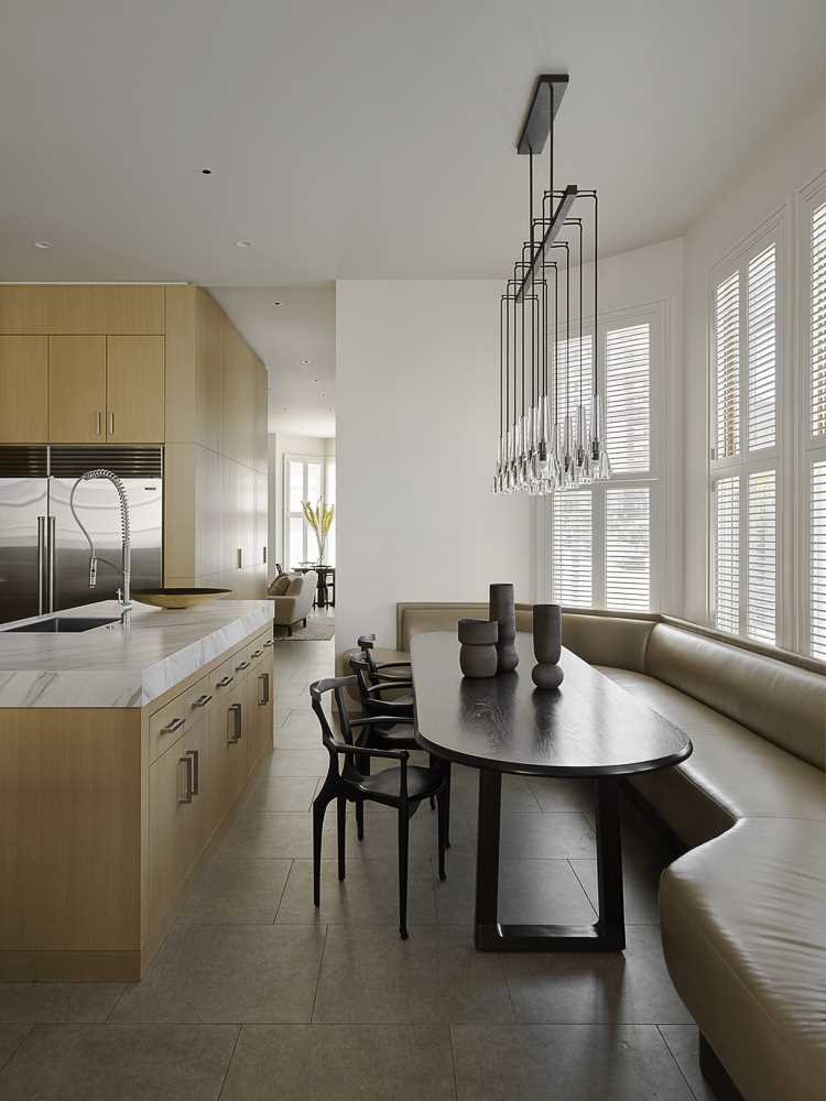 The hallway opens up into the kitchen and a banquette seating area that wraps around the wall.