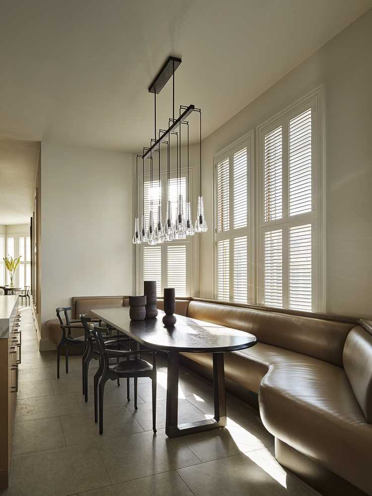 The hallway opens up into the kitchen and a banquette seating area that wraps around the wall.