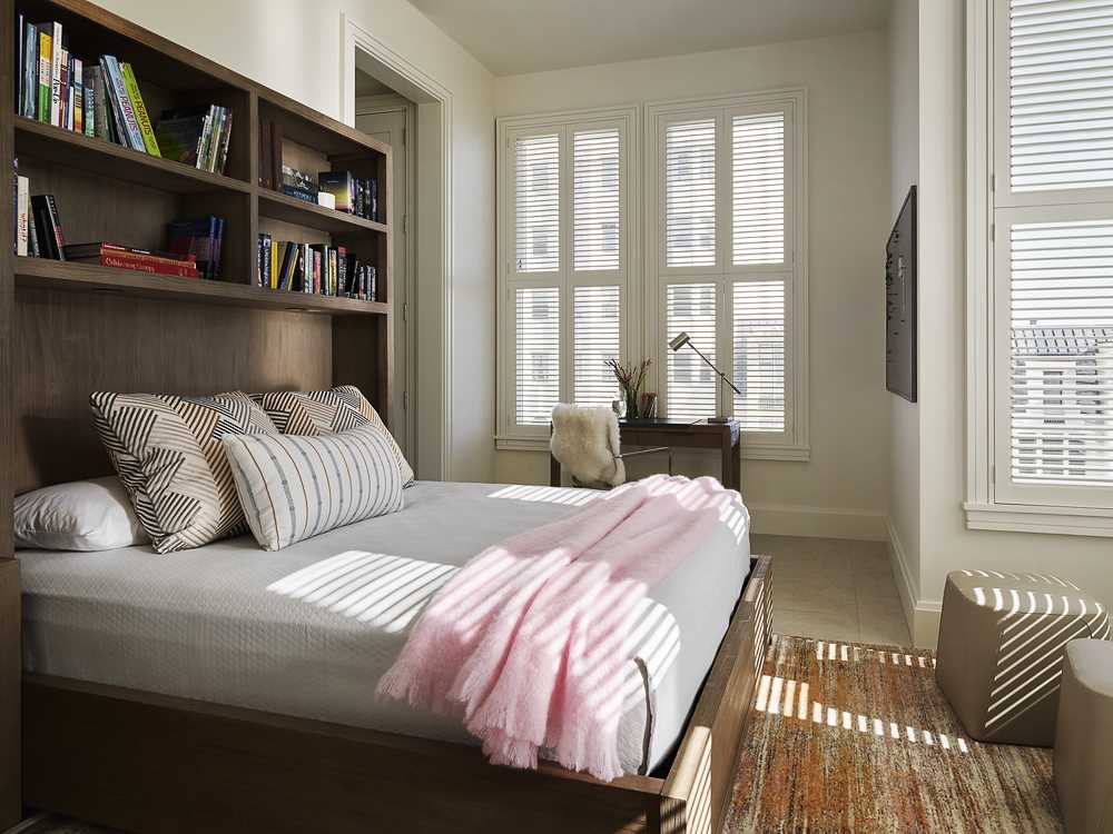 In this bedroom, there's a dark wood bed frame and headboard that contrast the light walls, while the view becomes the focal point.