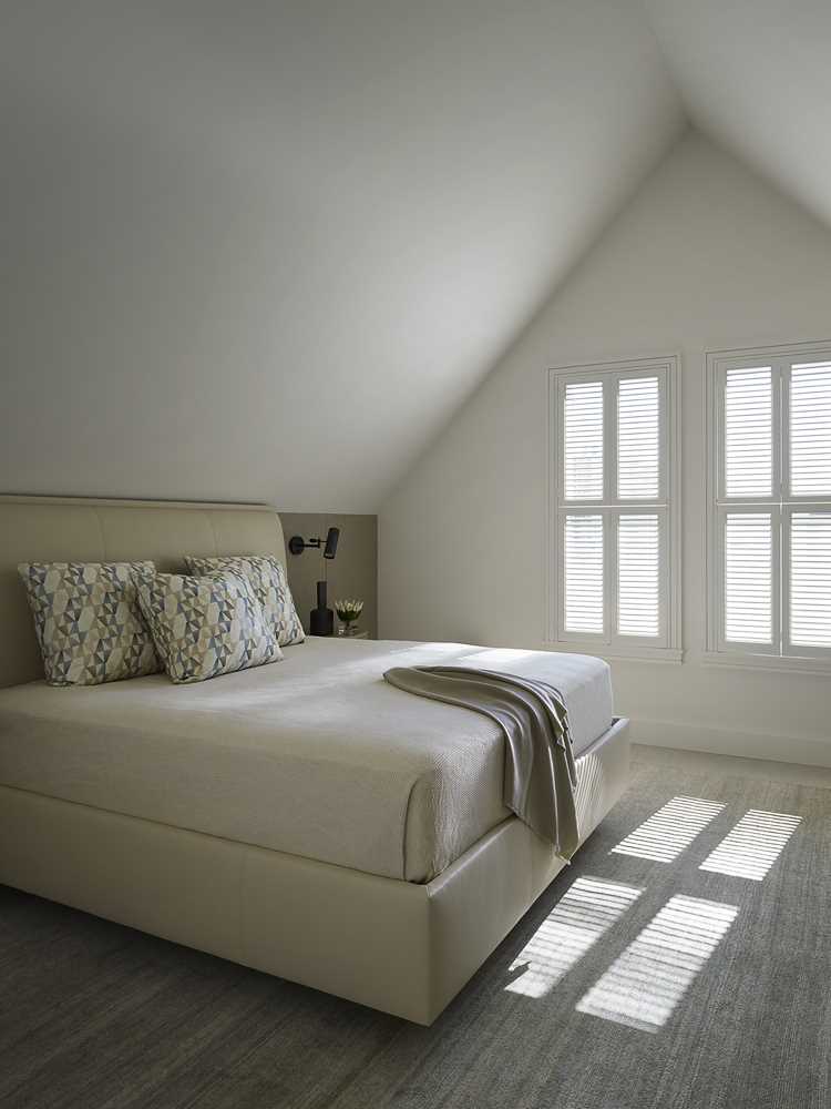 In this minimalist bedroom, the cathedral ceiling and light-colored walls make the room feel large.